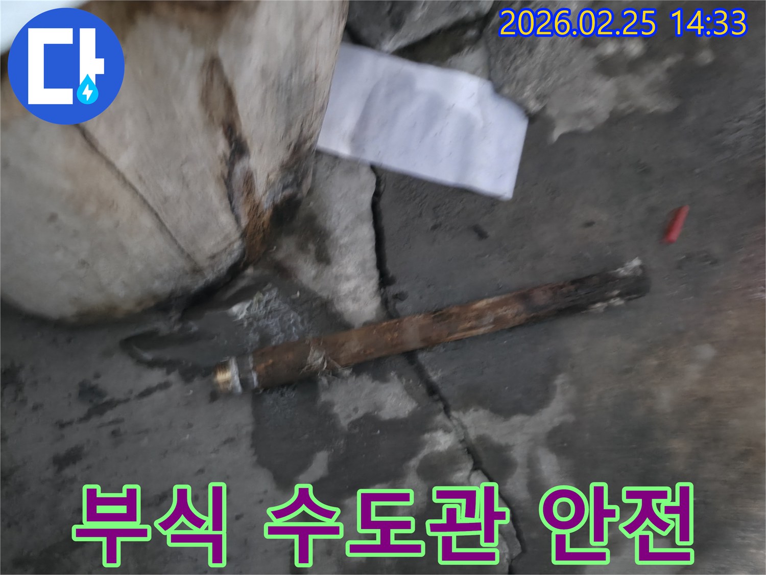 오래되어 부식된-파열된 수도관이-젖은 바닥에 놓여있는-누수 공사 현장 사진입니다.