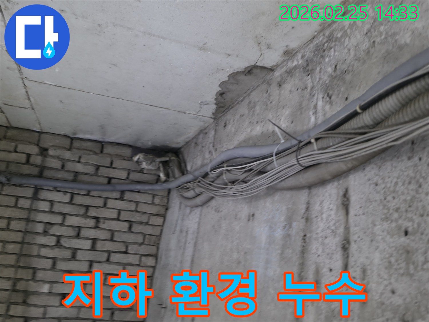지하 벽면의-콘크리트와-벽돌 벽이 만나는-지점에서-발견된-오랜 누수로 인한-물자국과-주변의 복잡한 배관