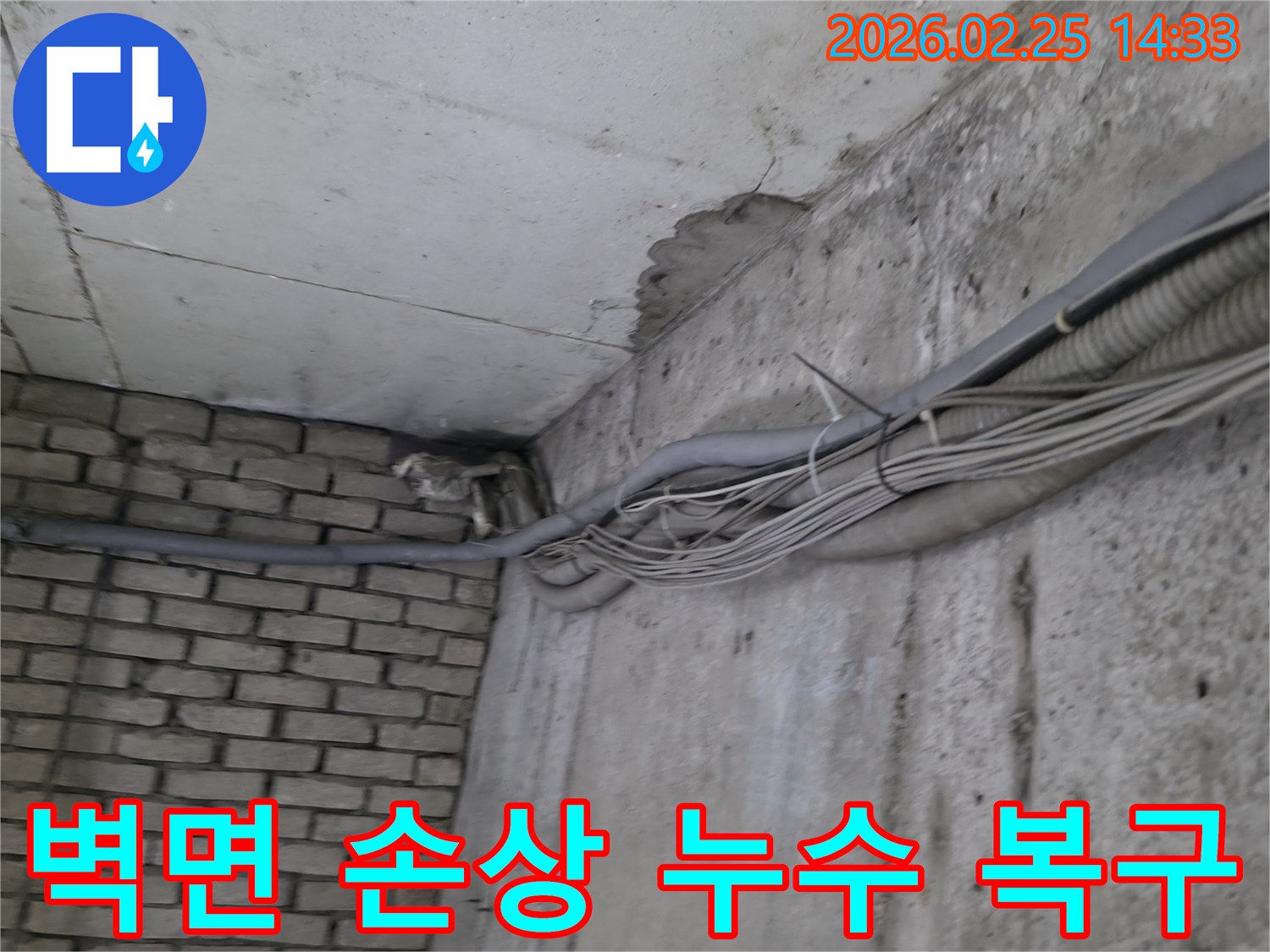 지하 벽면의-콘크리트와-벽돌 벽이 만나는-지점에서-발견된-오랜 누수로 인한-물자국과-주변의 복잡한 배관