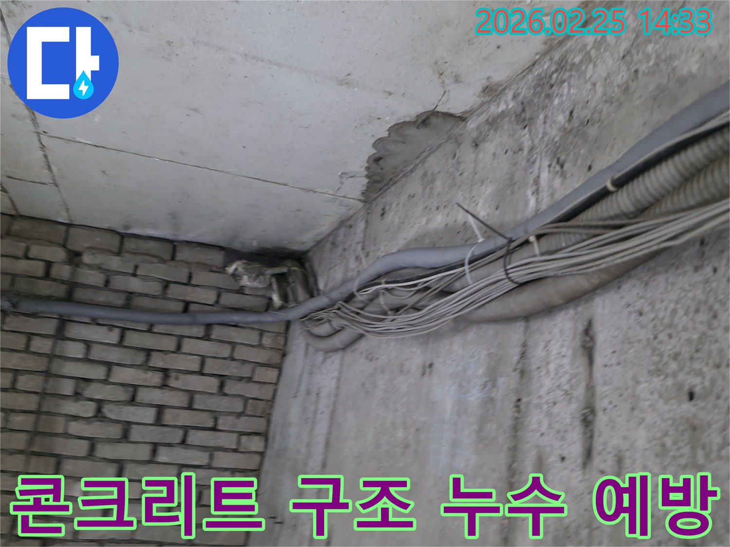 지하 벽면의-콘크리트와-벽돌 벽이 만나는-지점에서-발견된-오랜 누수로 인한-물자국과-주변의 복잡한 배관
