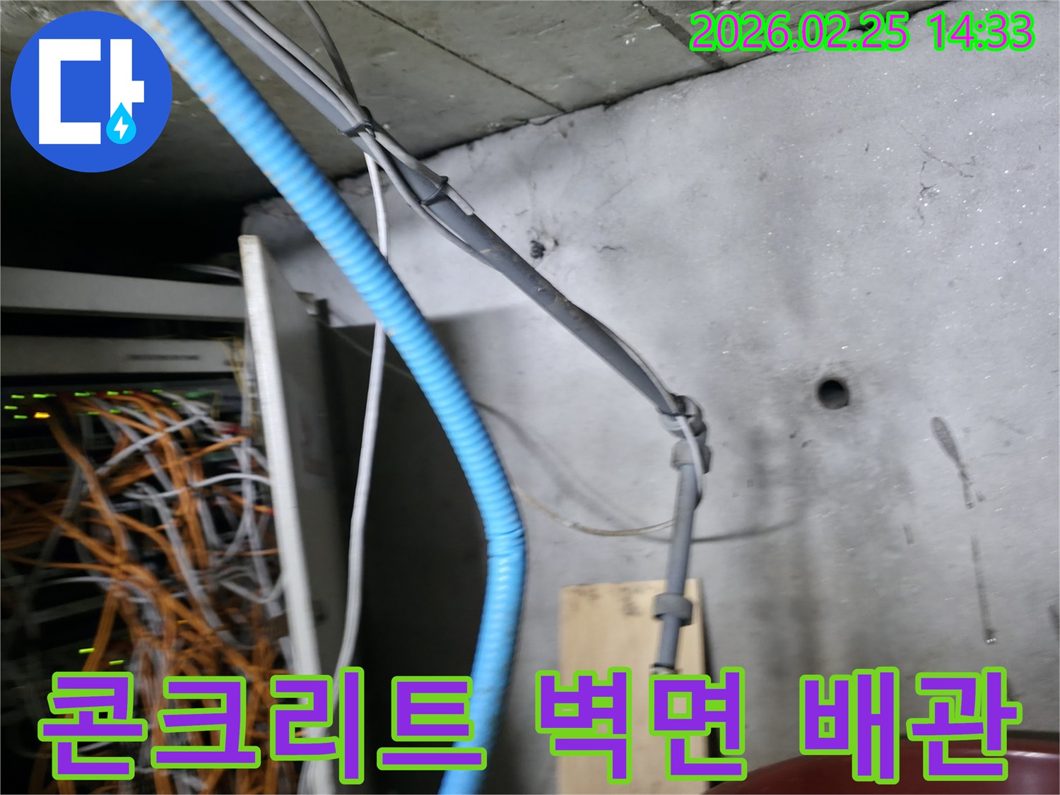 콘크리트 벽면에 고정된-파란색 주름관과 회색 케이블들이-누수 탐지 작업의-중요한 단서가 될 수 있음을-시각적으로 보여주는 현장입니다