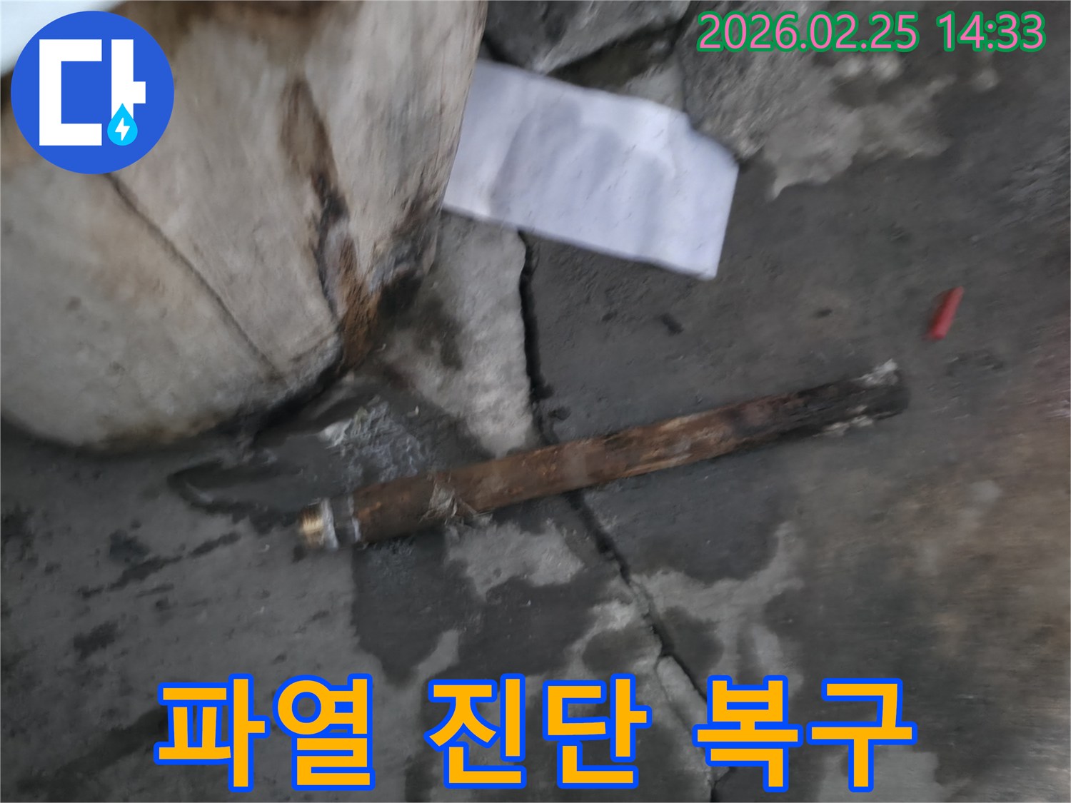파열된 오래된 배관이-젖은 바닥에 놓여있는-누수 공사 현장 사진입니다.