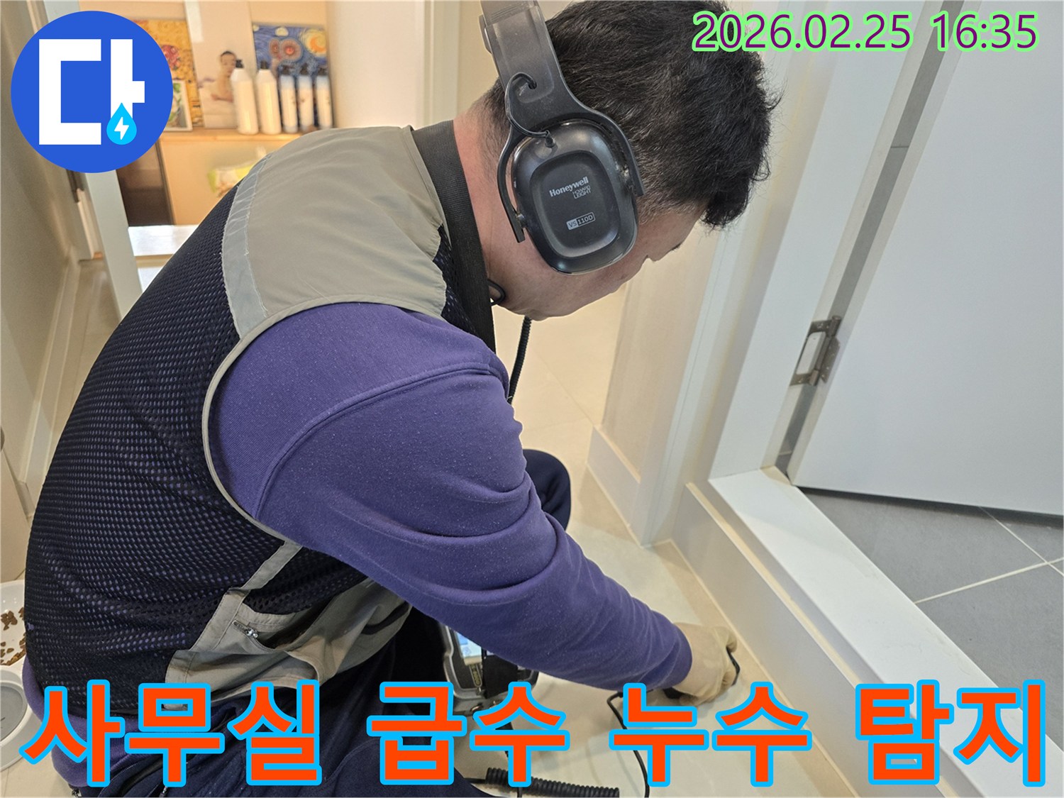 숙련된 누수 엔지니어가-청음식 탐지기를 이용해-사무실 바닥의-급수배관 누수 지점을-정밀하게 진단하고 있습니다