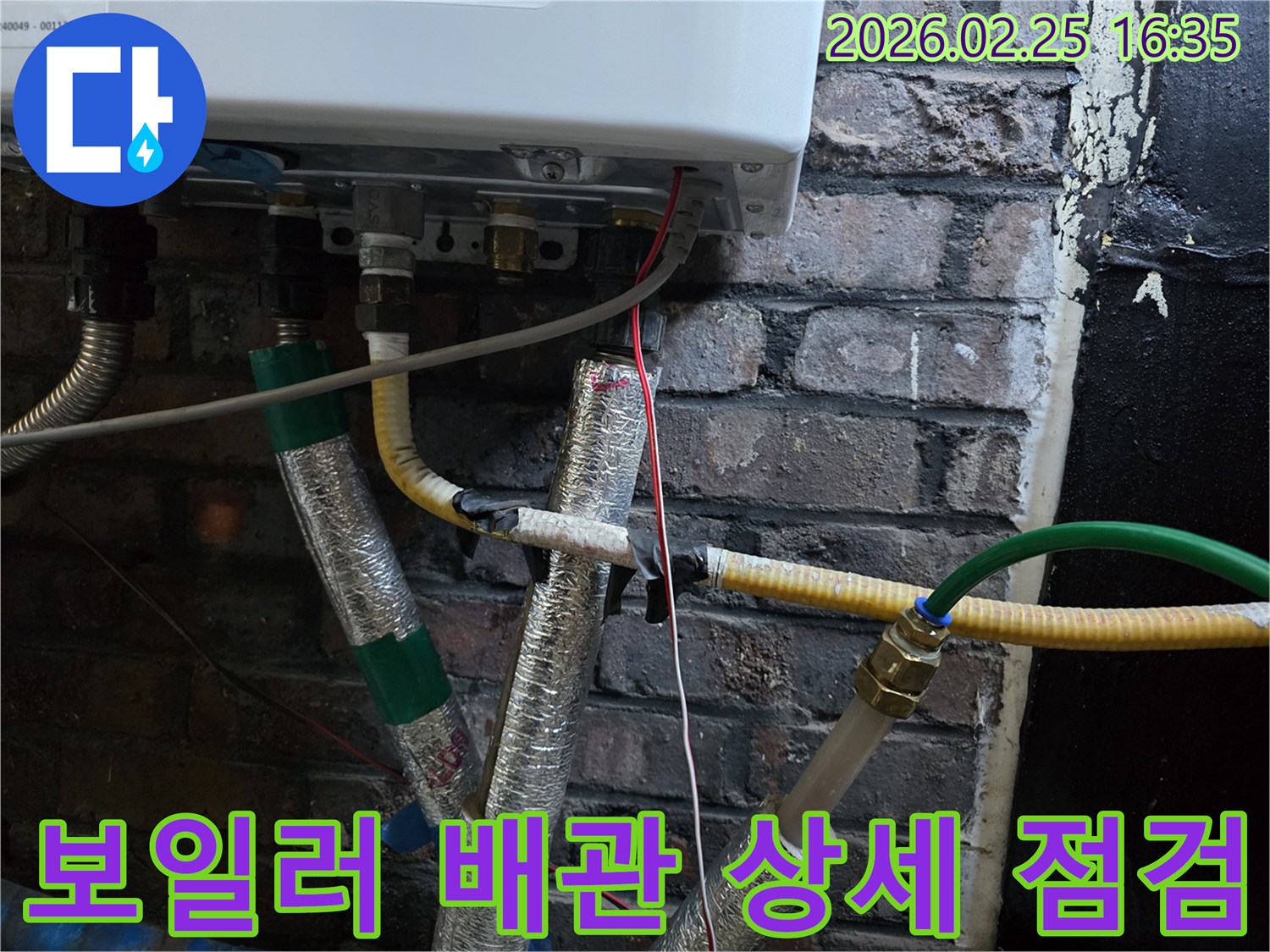 이 사진은-보일러 하단에-연결된-다양한-수도관과-가스관-그리고-전선이-복잡하게-얽혀있는-모습을-보여주며-일부 배관은-단열재로-감싸져 있습니다.