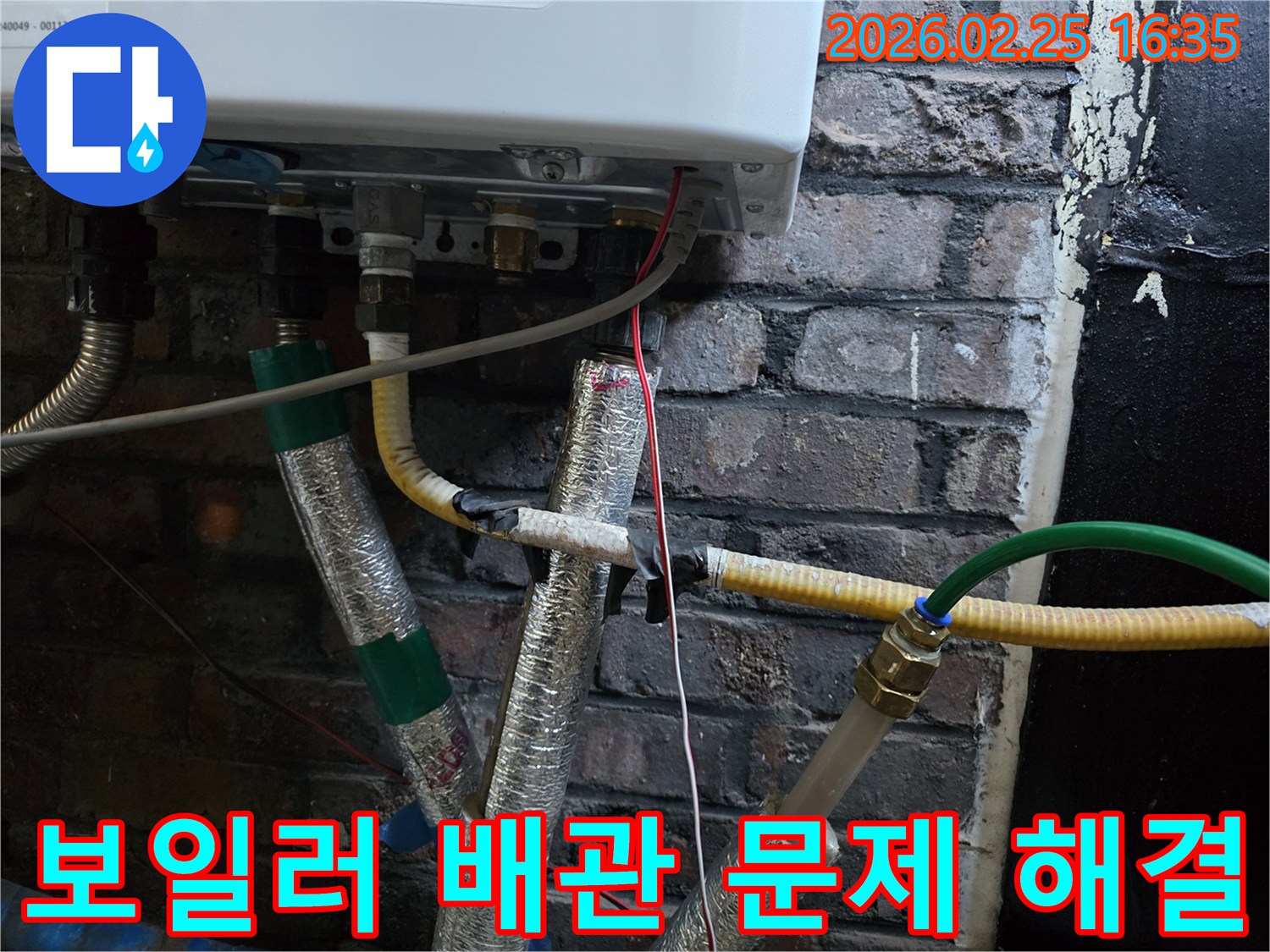 이 이미지는-벽에 설치된-보일러 하단부의-복잡한 배관 연결부와-전선-그리고-은색 단열재로-감싸진-파이프들을-보여주며-누수 문제 해결을-위한-정밀한 점검이-진행되고-있음을-암시합니다.