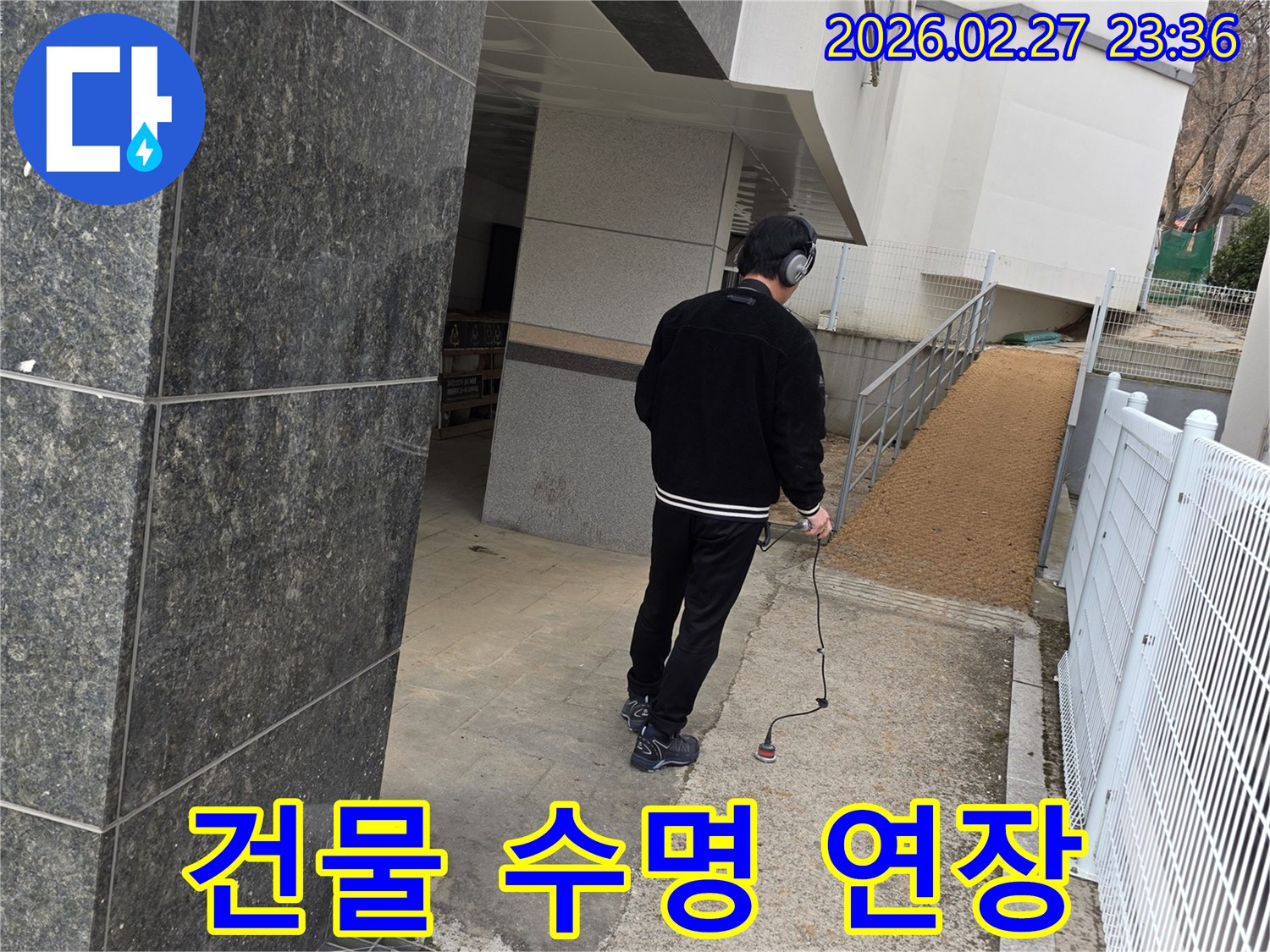 누수 엔지니어가-청음식 탐지 장비로-건물 외부의-누수 지점을 정밀하게 진단하여-건물 수명 연장에 기여하는 모습
