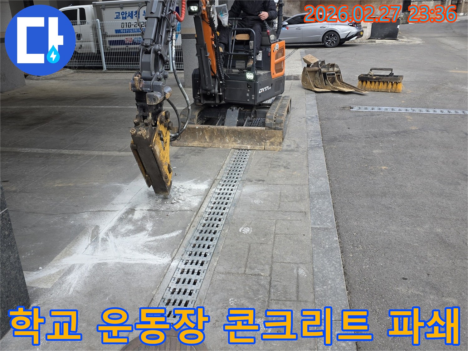 호국로-인근-학교-운동장-누수-수리를-위해-미니굴삭기로-콘크리트를-파쇄하고-배관을-수리하는-현장