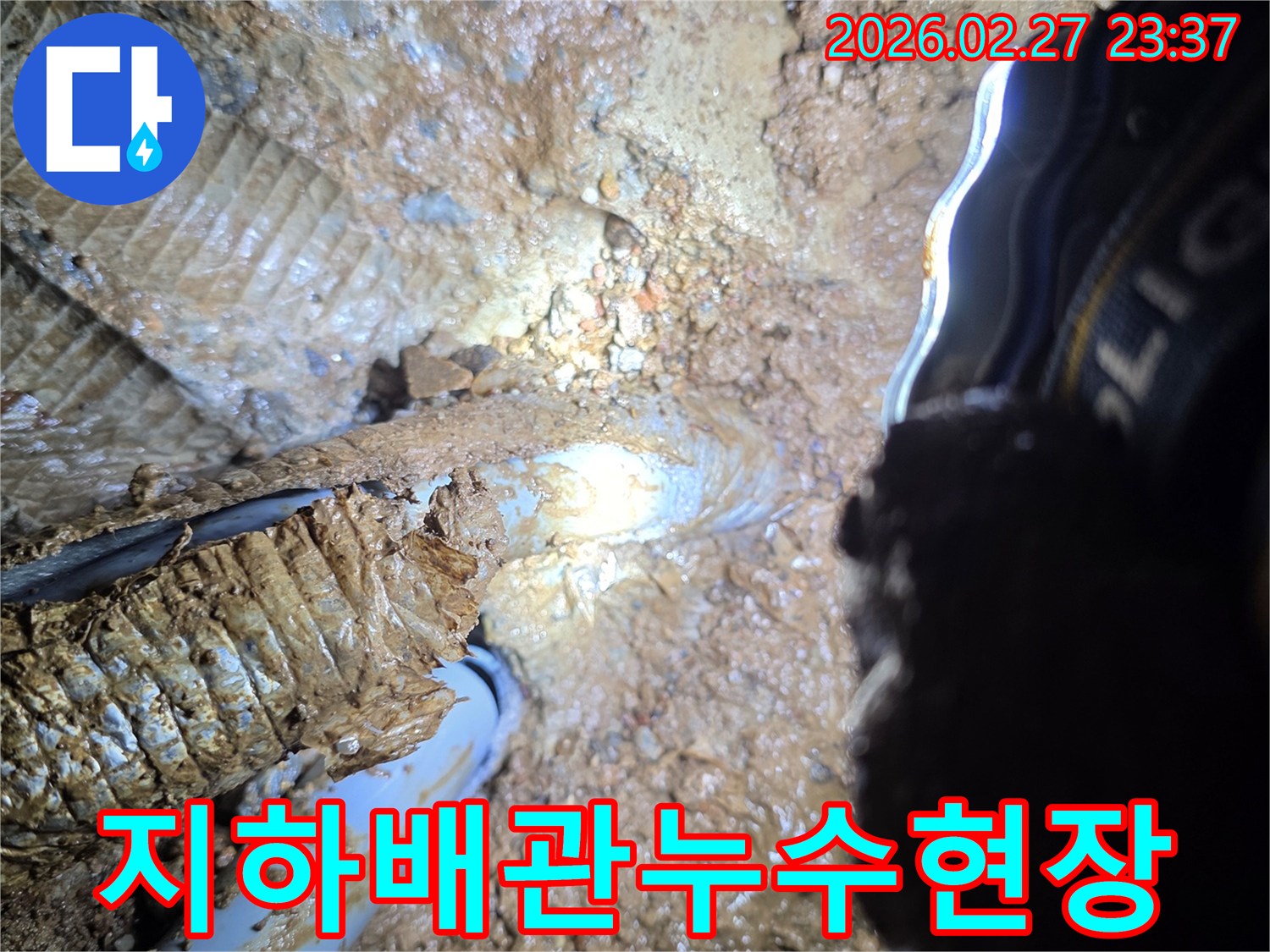 흙에-묻혀-누수가-발생한-지하-배관의-모습을-확대하여-보여주는-사진