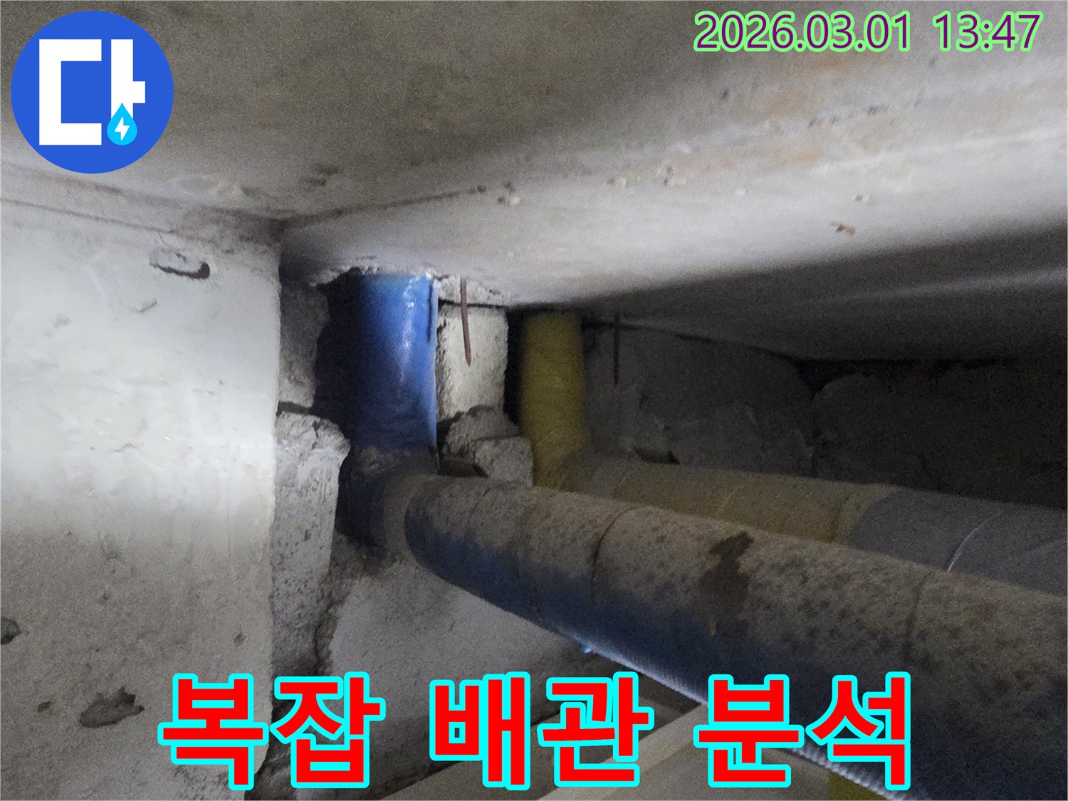 콘크리트 벽면 안쪽의-복잡하게 얽힌 배관 구조를-면밀히 분석하는-현장 사진입니다.