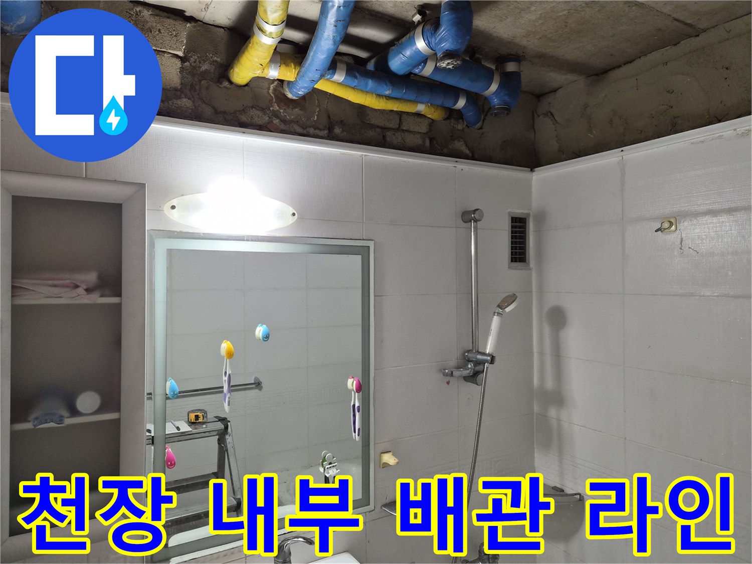 화장실 천장 마감재 안쪽의 노란색 및 파란색 보온재 배관 모습