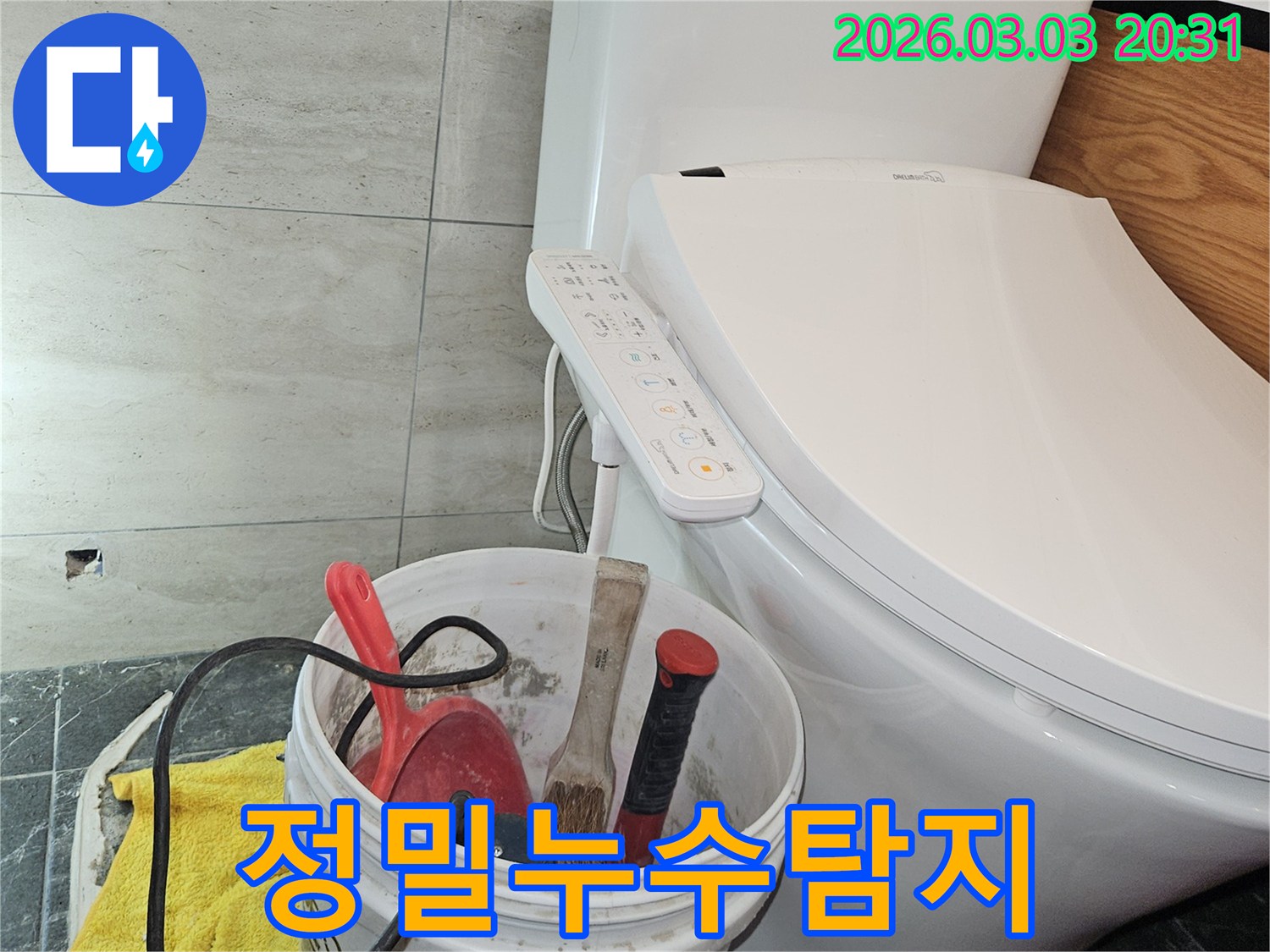 이 사진은-변기 옆에 놓인 작업 도구들을 통해-화장실 누수 문제를 해결하기 위한-준비 과정을 보여줍니다.