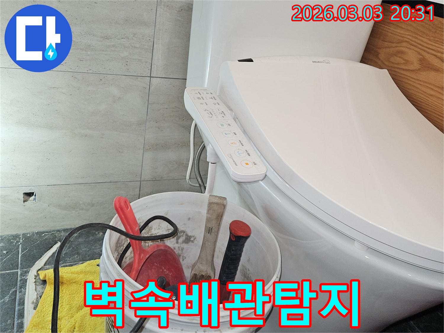 이 이미지는-화장실 벽 속에 숨어있는 배관 누수를-전문적으로 탐지하고 수리하기 위해-공구들이 준비된 현장 모습을 보여줍니다.