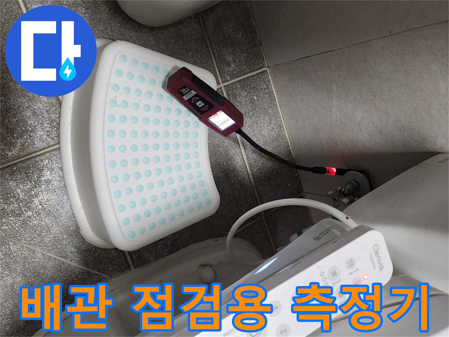 변기 옆 바닥에 놓인 전기식 누수 탐지 장비와 연결선