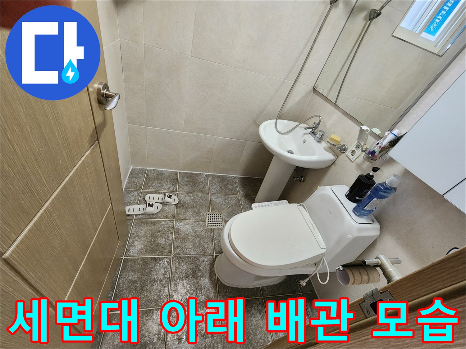 세면대 하부의 급수 밸브와 연결된 배관의 근접 촬영본입니다.