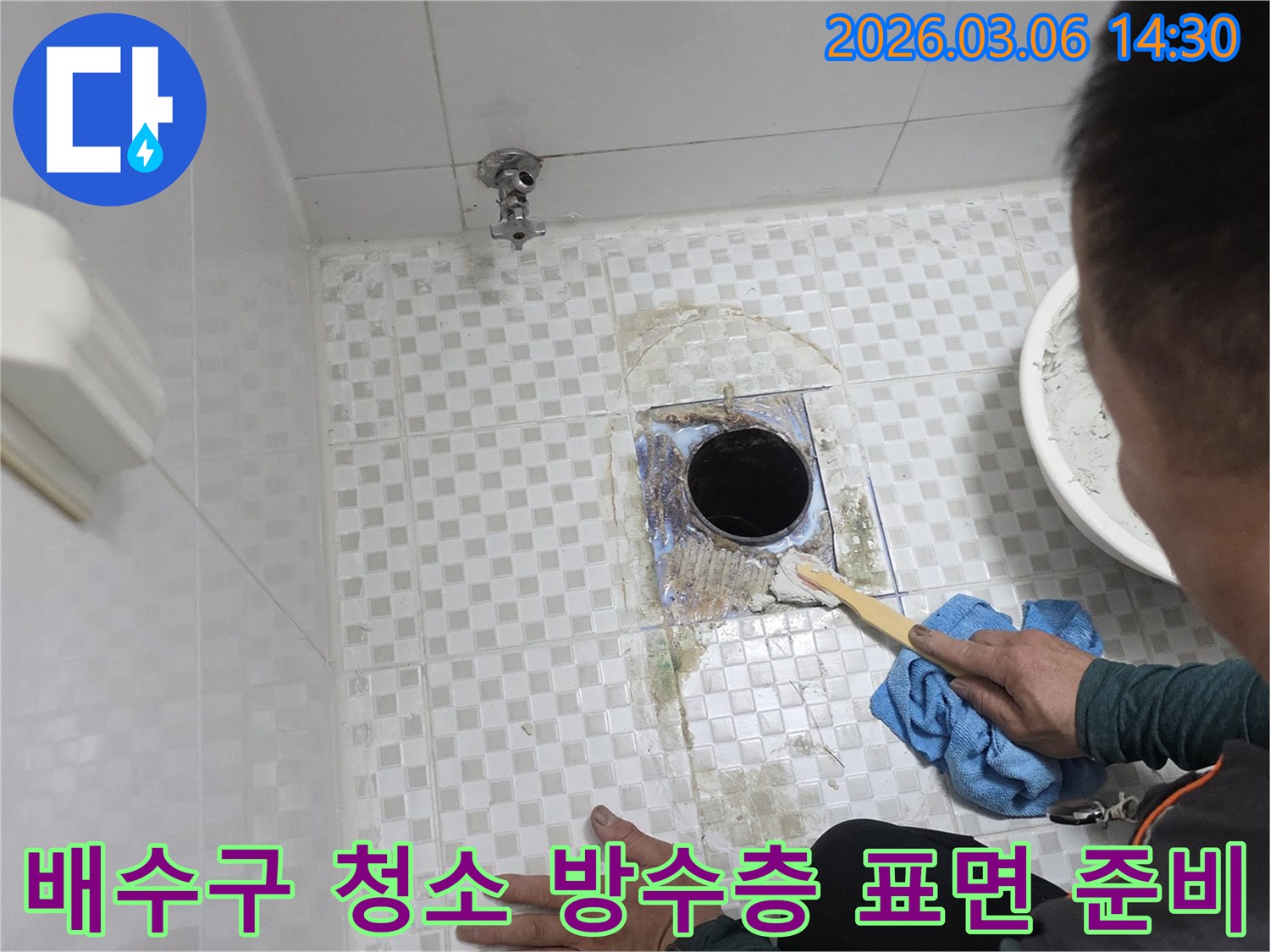빌라 욕실의-배수구 주변 누수를-해결하기 위해-오래된 마감재와-오염 물질을-제거하며-방수층 재시공을 위한-표면을 준비하는-작업입니다