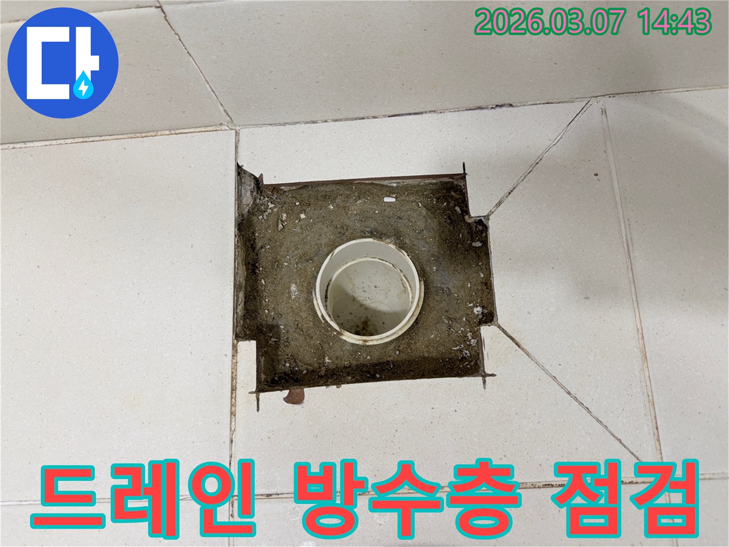 주택 내부에서 발생한-누수의 근본적인 원인을 파악하고자-바닥 타일을 제거한 후-배수관을 점검하는 현장 사진입니다