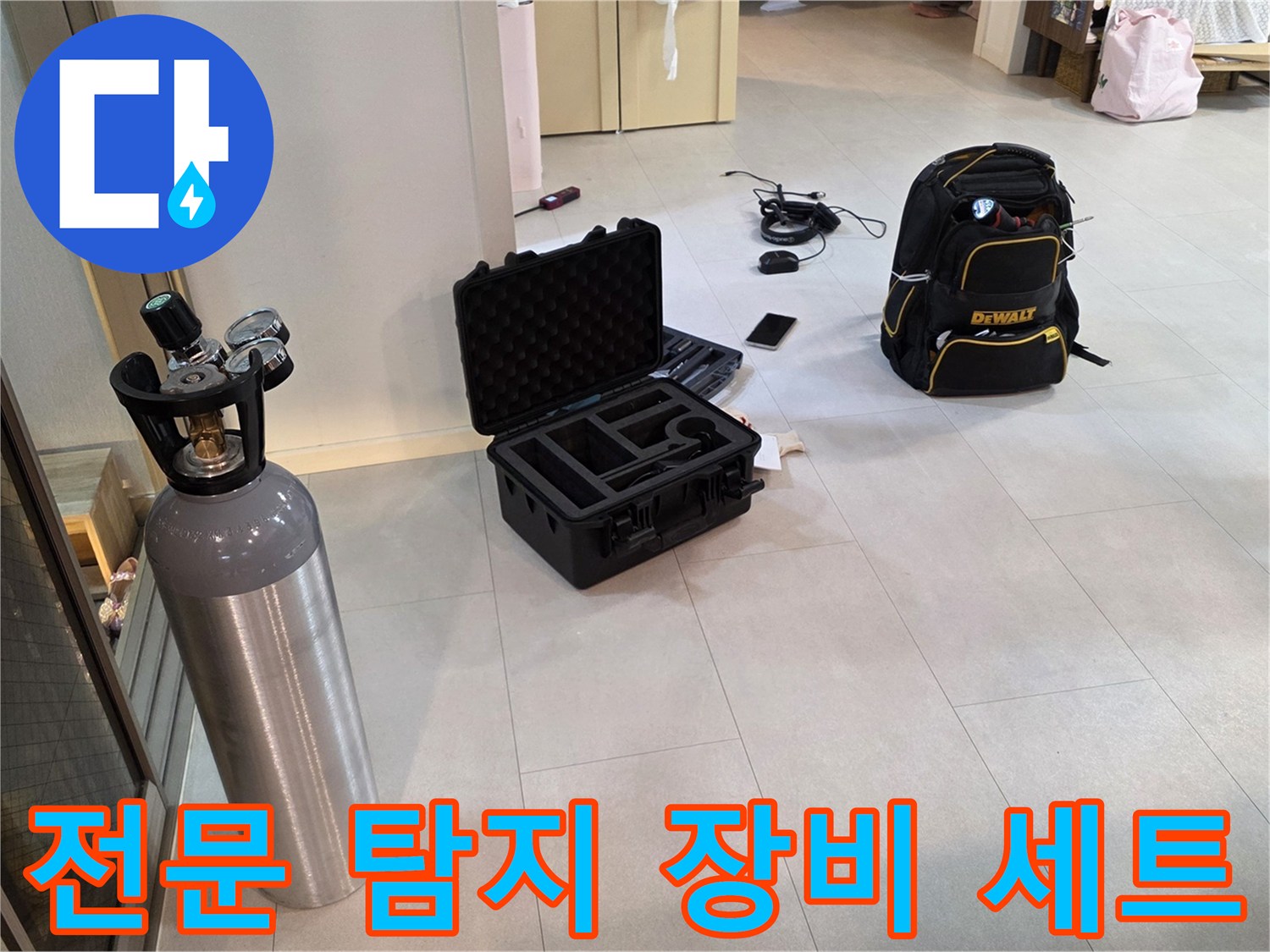 누수 지점 탐색을 위해 바닥에 펼쳐진 가스통과 전문 공구 케이스