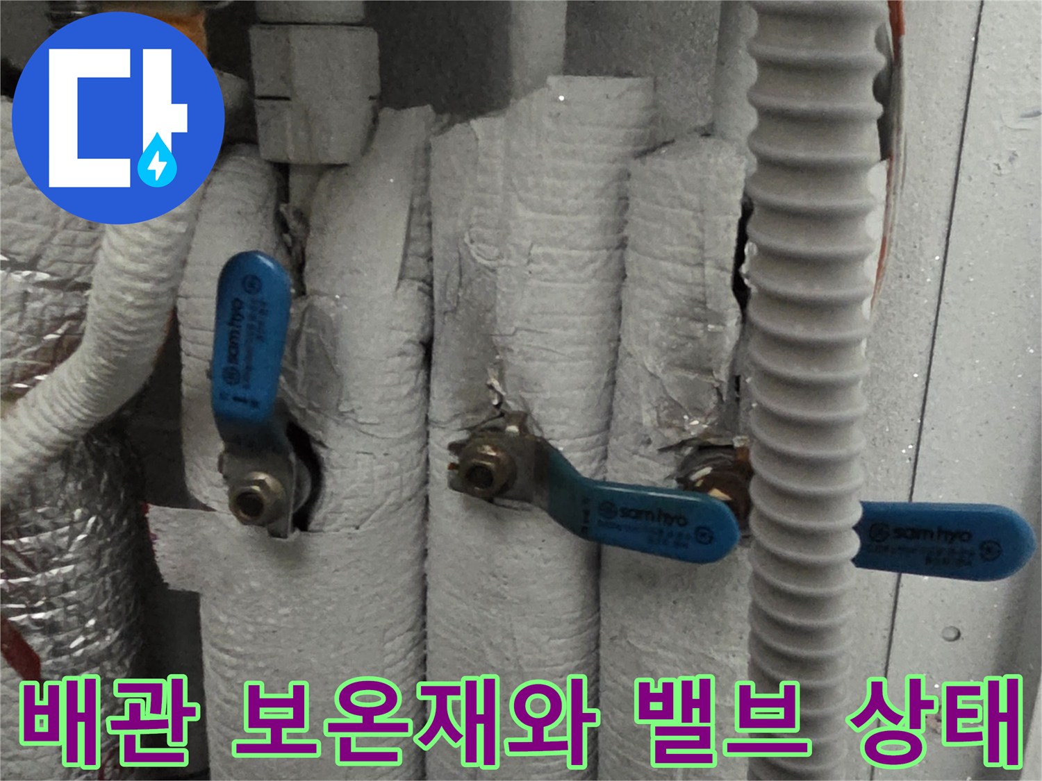 보온재로-감싸진-배관과-파란색-제어-밸브의-근접-촬영
