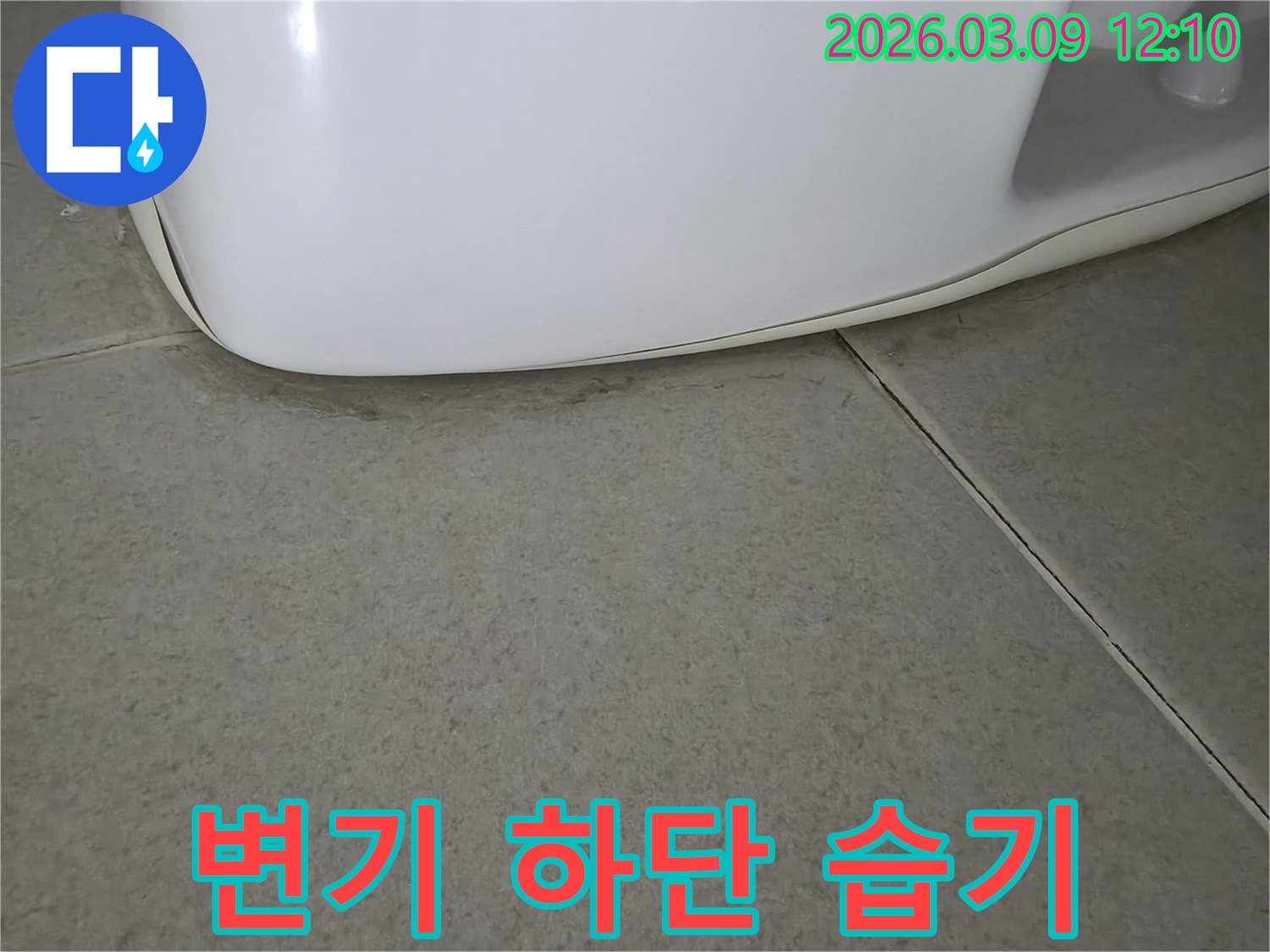 변기 하단과-바닥 타일 사이로-물이 스며들어-습기가 침투한-모습으로-누수 발생을-명확히 보여줍니다