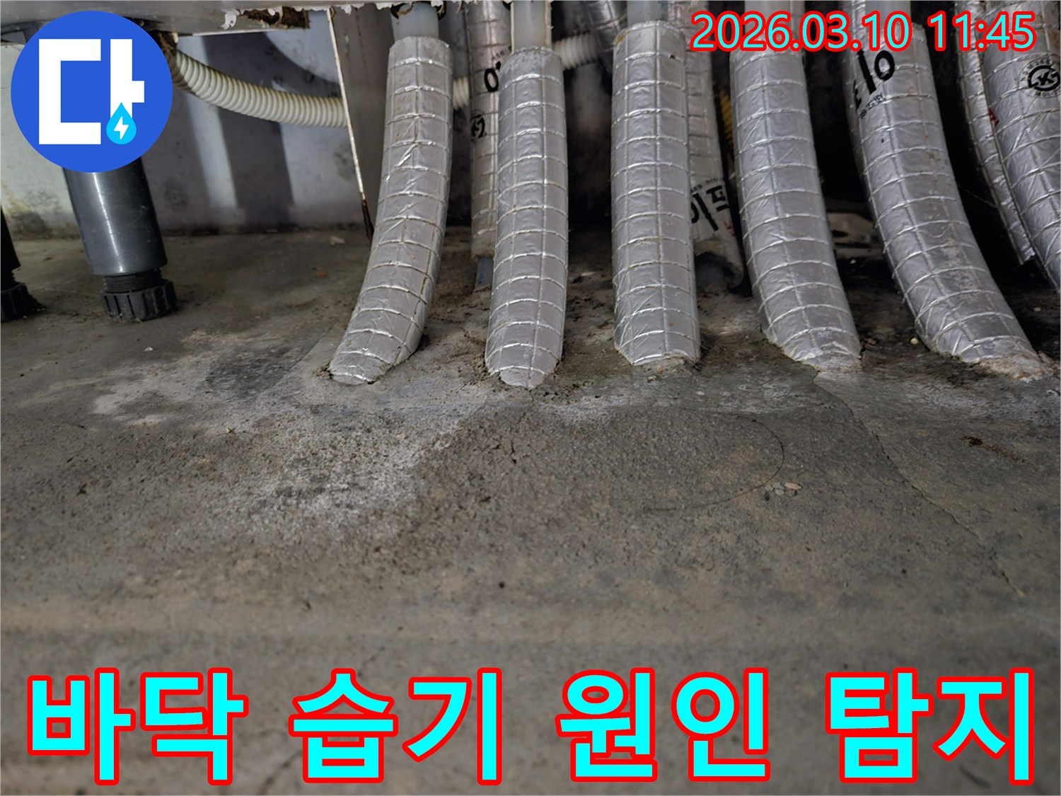 콘크리트-바닥에-단열된-배관들이-연결된-지점에서-발견된-습기와-백화-현상을-촬영한-사진입니다