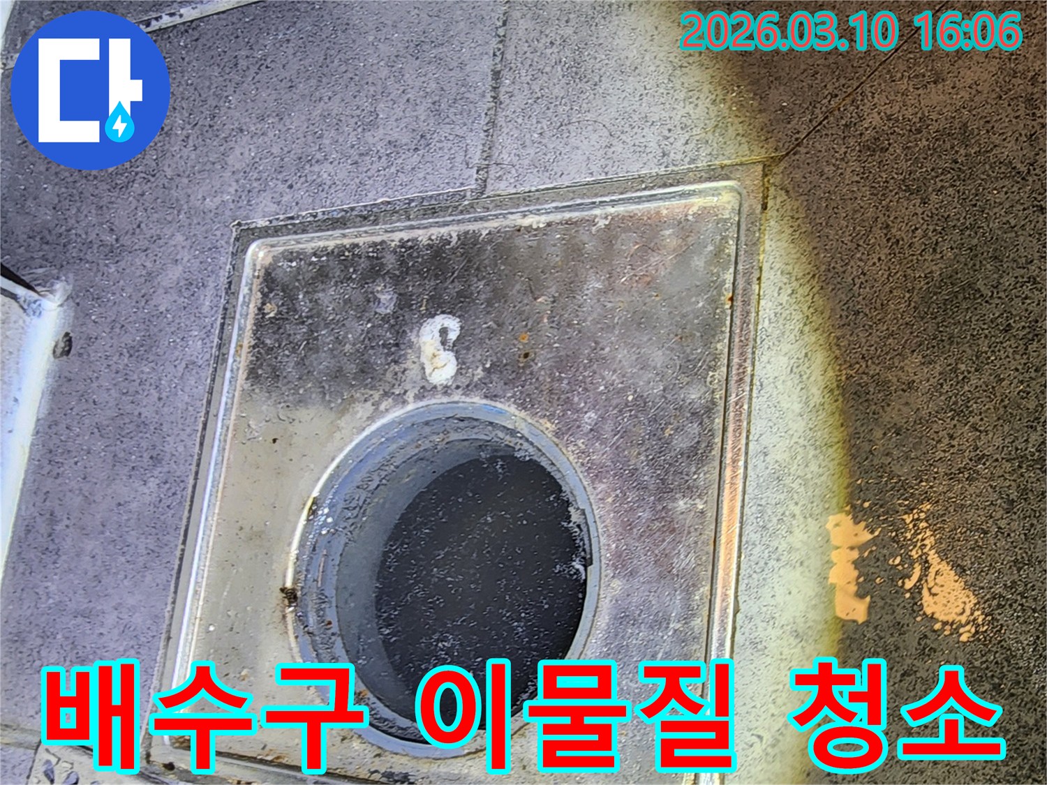 이 이미지는-서울 중구의 한 건물에서-누수 점검을 위해-배수구 주변의 이물질을 제거하고-청소하는-과정을 보여줍니다