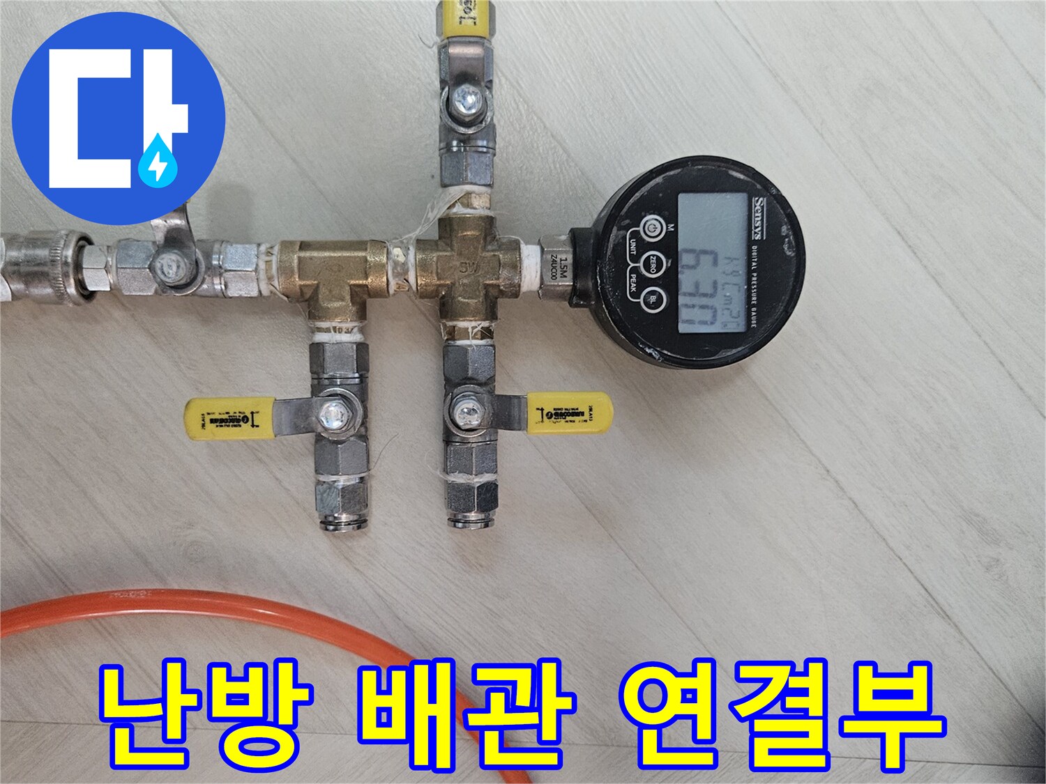 노란색 호스와 연결된 배관 밸브 및 압력계