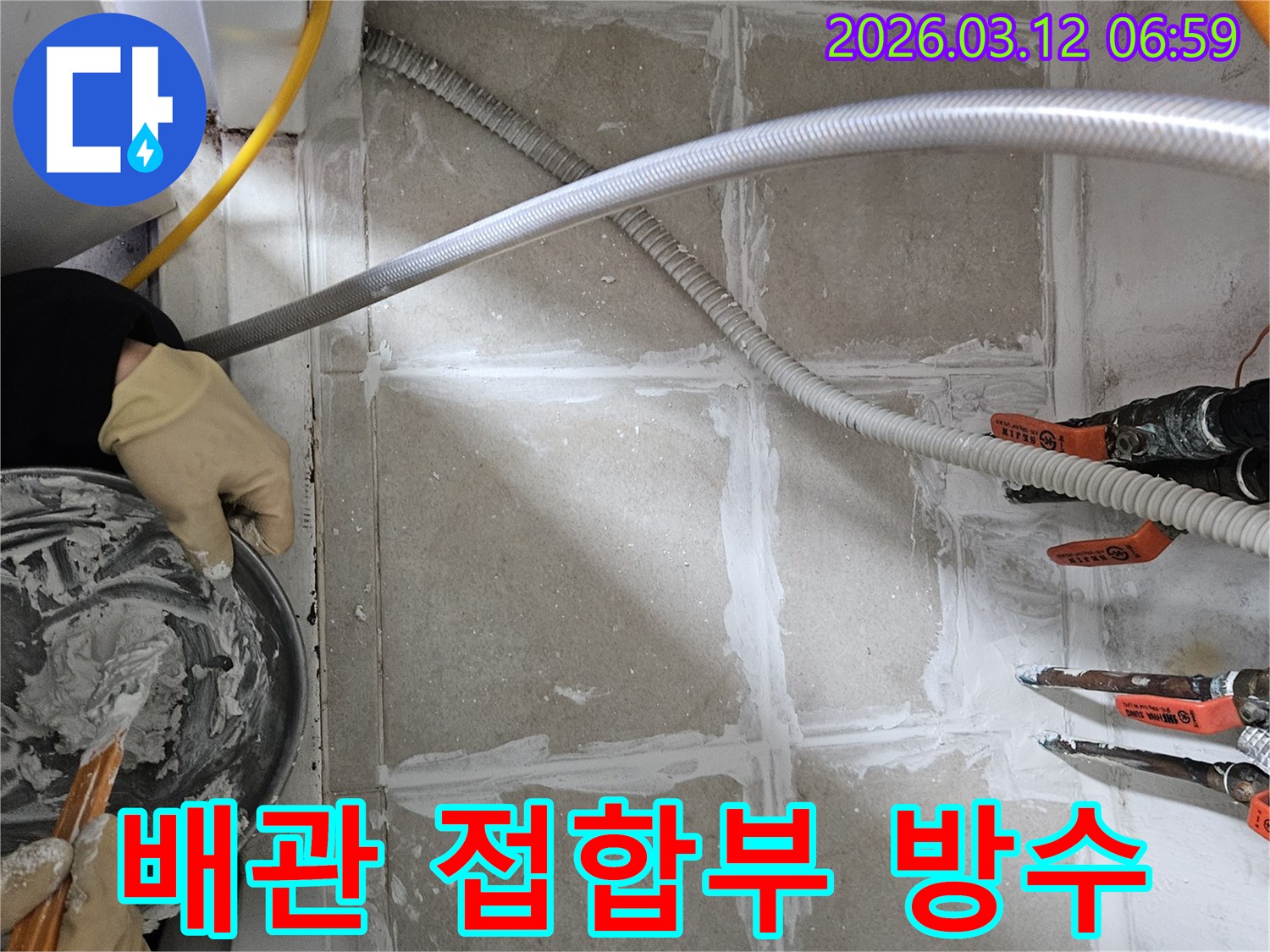 누수 엔지니어가 상가 배관과 바닥의 접합부에 누수 방지용 실링 작업을 세밀하게 적용하고 있습니다