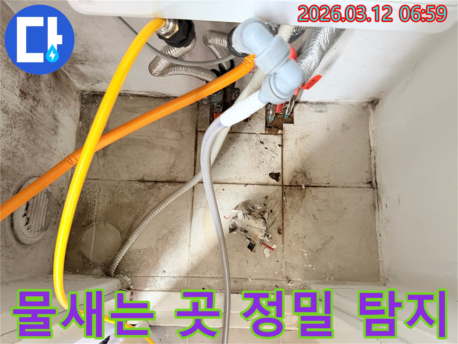 바닥에 물기가 보이고-오염된 타일과 배관들이-물샘 현상을 시사하는-현장 사진입니다.