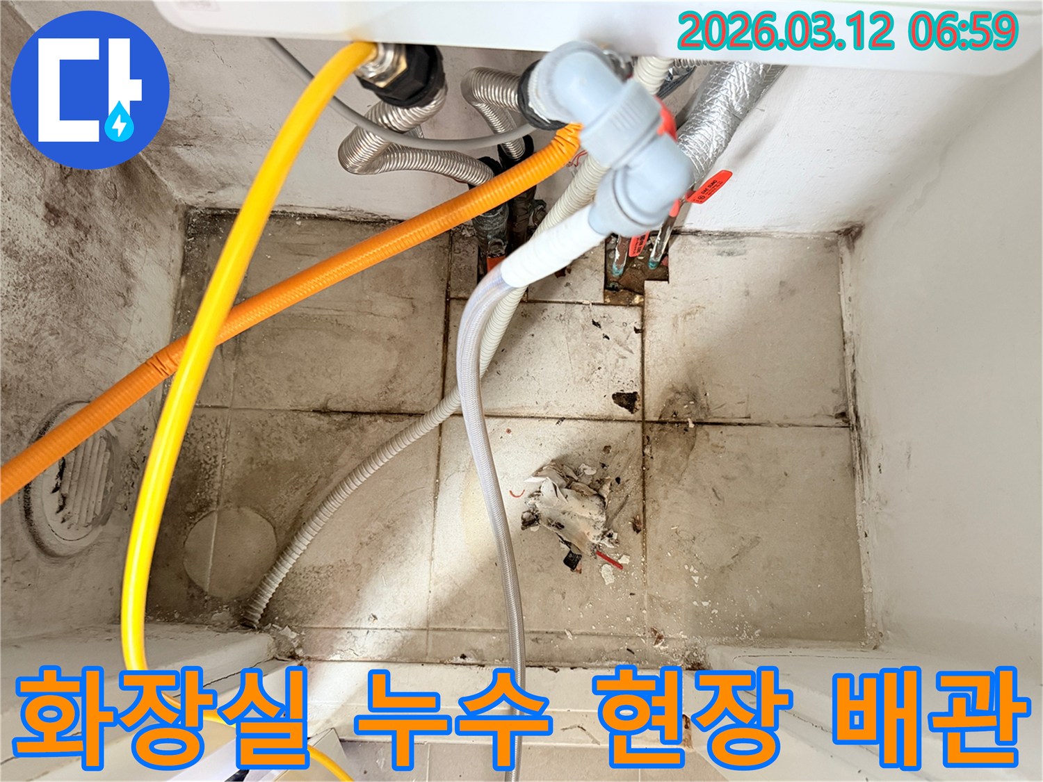 화장실 바닥의-오염된 타일과-벽면의 곰팡이-그리고 복잡한 배관들이-누수 문제를 시사하는-현장 사진입니다.