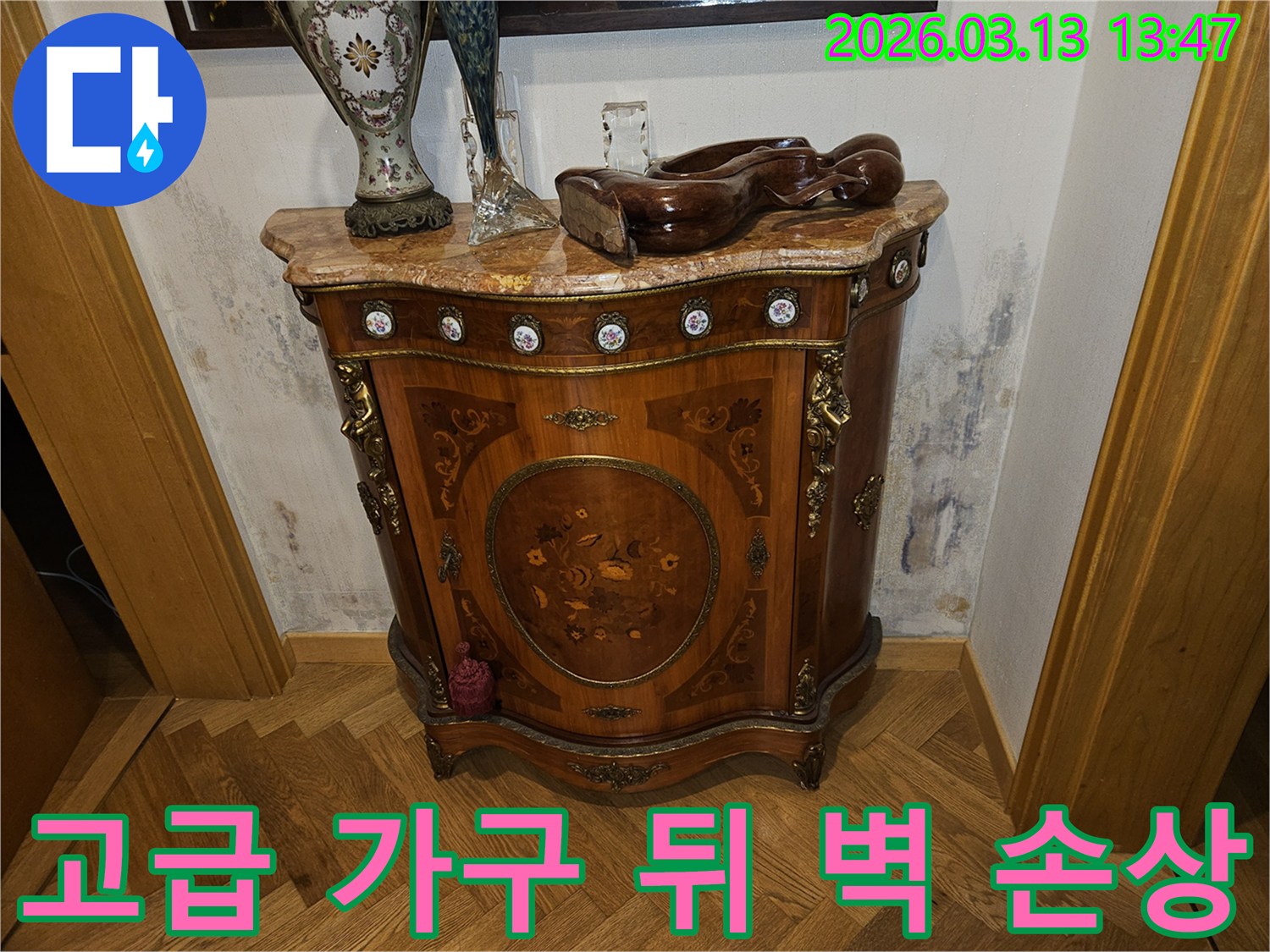 고풍스러운 가구 뒤편-벽에 누수로 인한-심각한 벽지 손상과-곰팡이가 보이는 장면