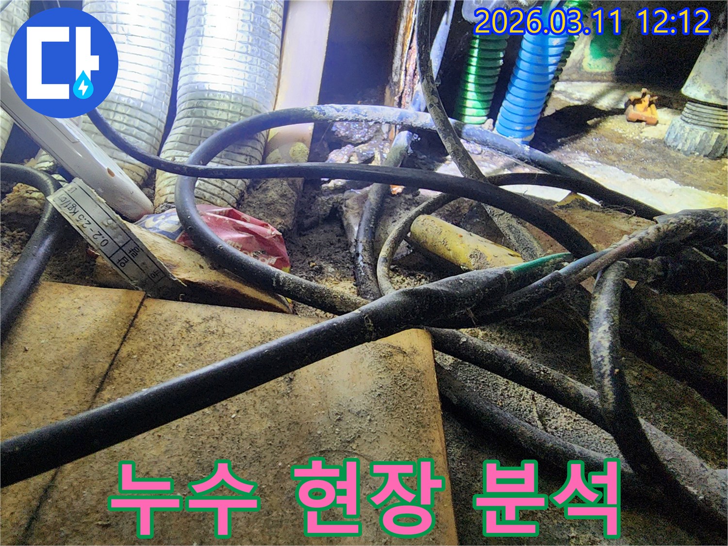 누수-공사 현장에서-복잡하게-얽힌-배관과-전선-사이의-작업-환경을-보여주는-사진입니다.