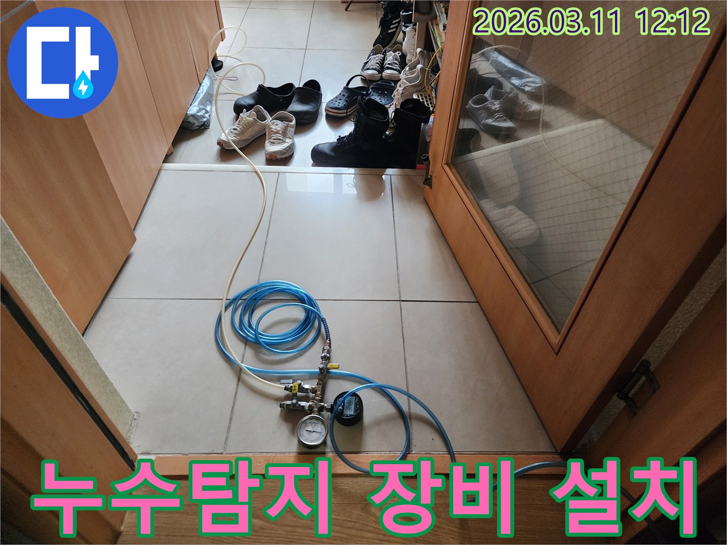 누수 탐지 작업을 위해 압력 게이지가 달린 호스를 연결하고 있는 모습