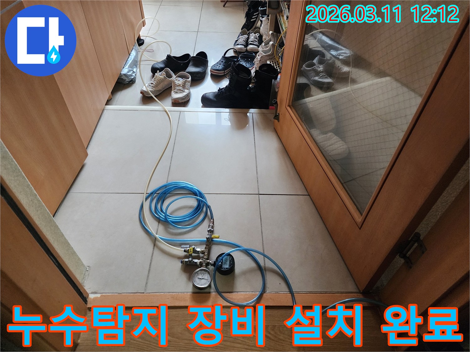 누수 탐지 작업을 위해 압력 게이지가 달린 호스를 연결하고 있는 모습
