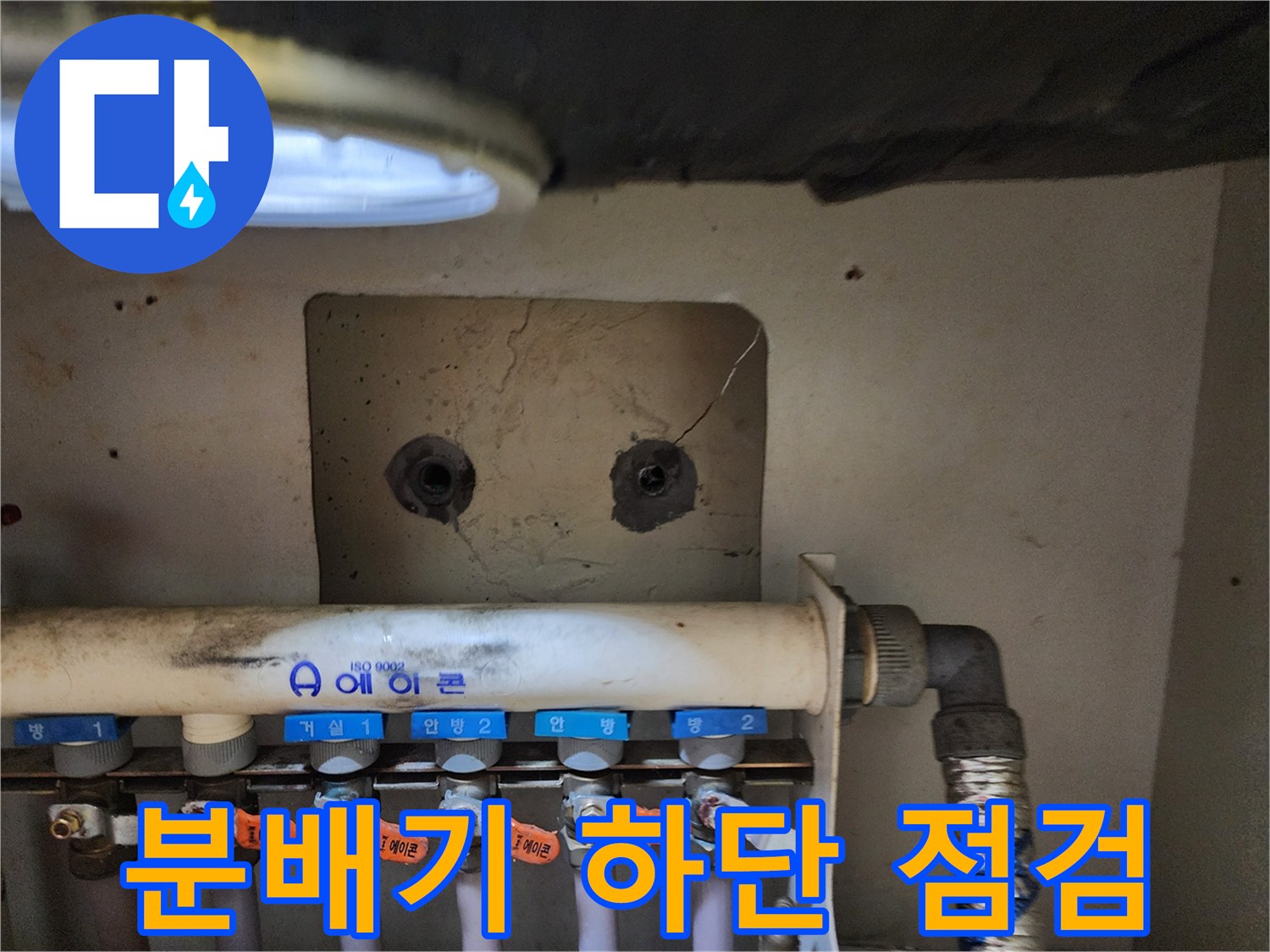 싱크대 아래 설치된 난방 분배기 밸브와 배관 모습