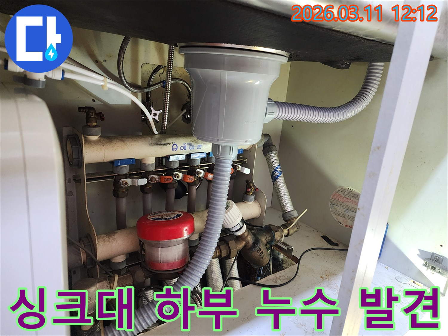 싱크대 하부의 복잡한-물건들-사이에서-발견된-누수-지점을-정확히-탐지하는-전문가의-모습