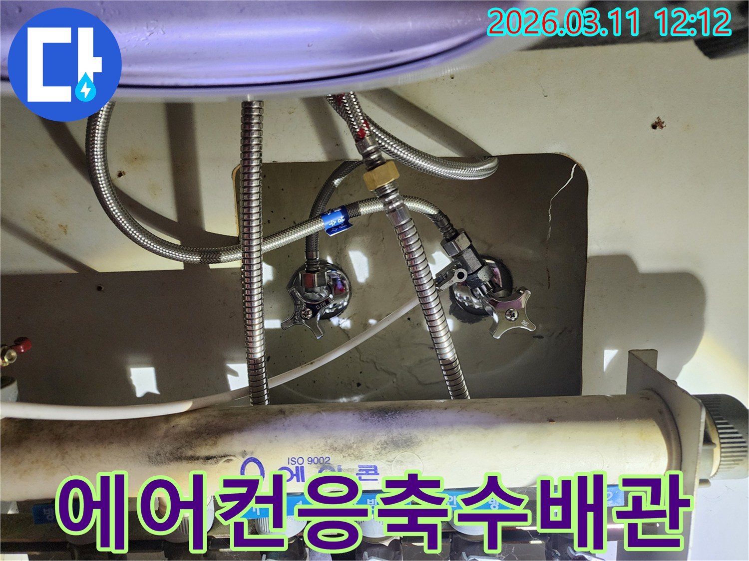 싱크대-하부의-에어컨-응축수-배관과-연결된-수도-라인을-누수-전문-엔지니어가-정밀하게-점검하는-사진