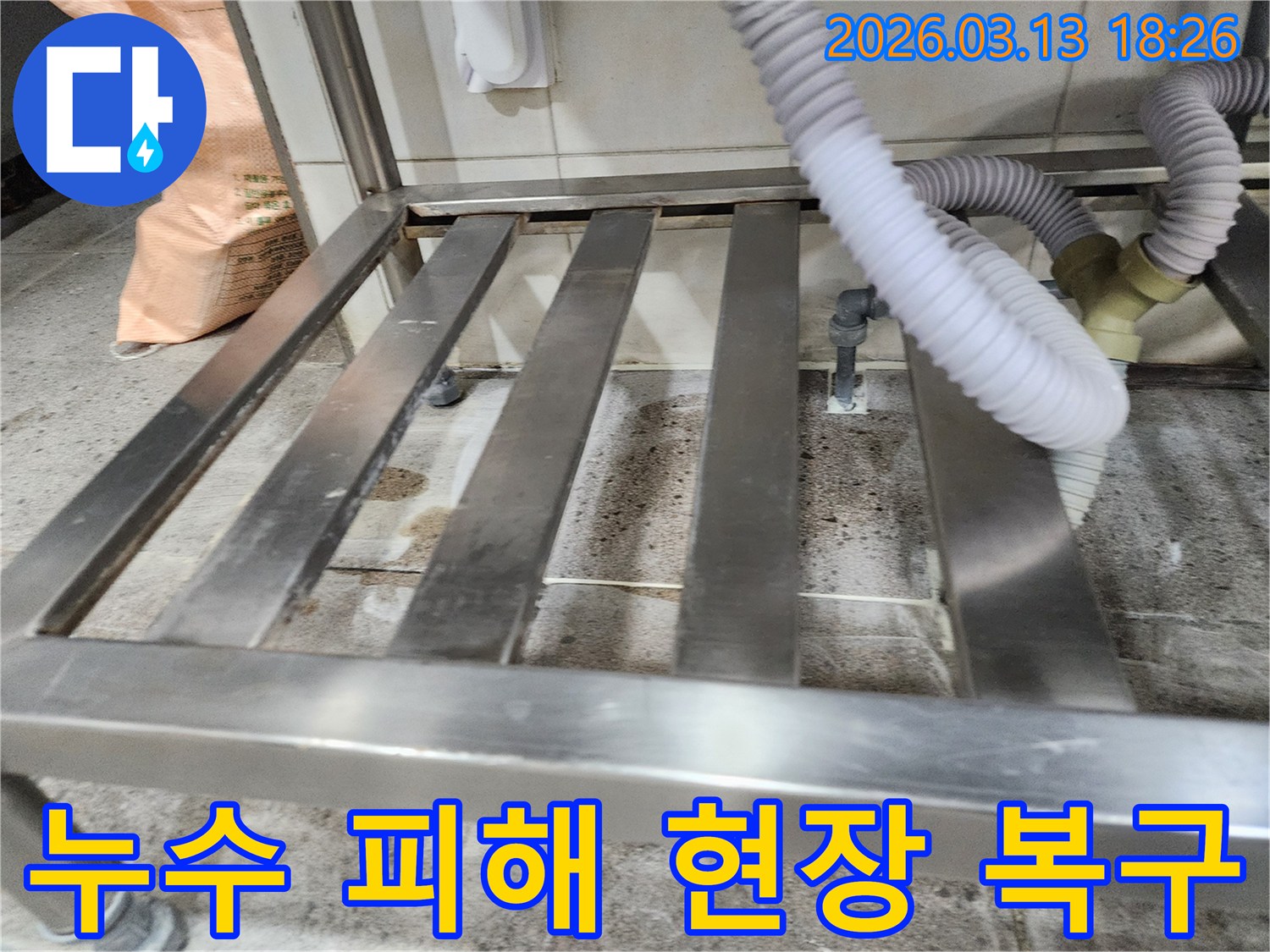 누수-발생 현장에서-물기로 인해-손상된 바닥과-배관 주변을-점검하고-복구 계획을-세우는 모습
