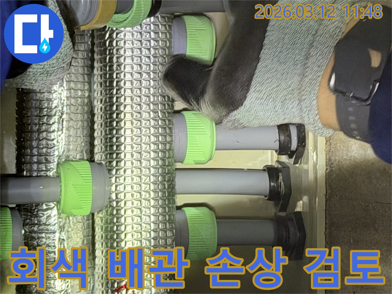 김포-지역의-누수-전문가가-회색-배관의-표면을-면밀히-검토하며-손상-여부를-확인하고-있습니다.