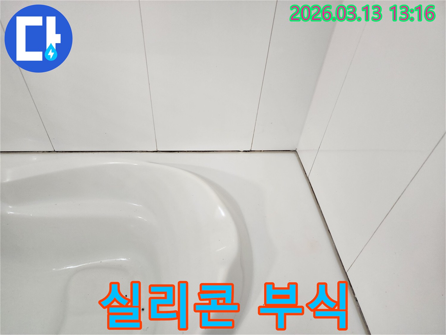 욕실 변기 주변-타일과 위생도기 사이의-실리콘이 부식되고-검게 변색된 모습을-확대하여 보여주는 사진