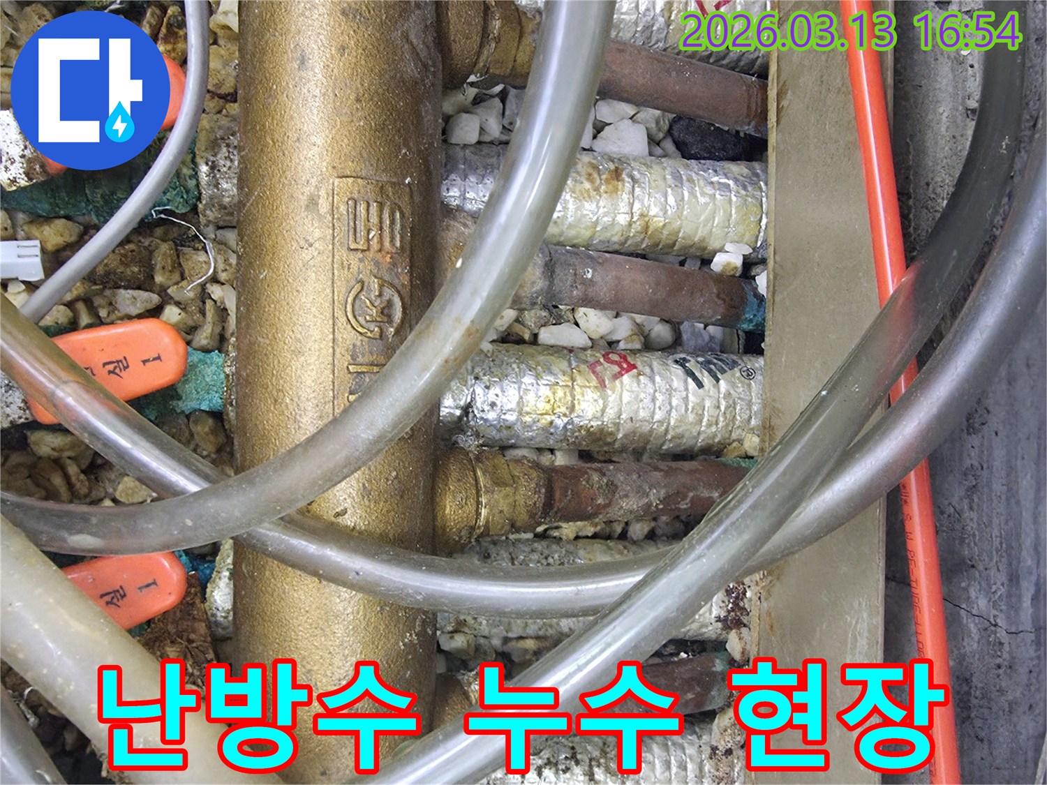 분배기 주변의-작은 자갈과-다양한 배관들이-얽혀있는-누수 현장 사진입니다.