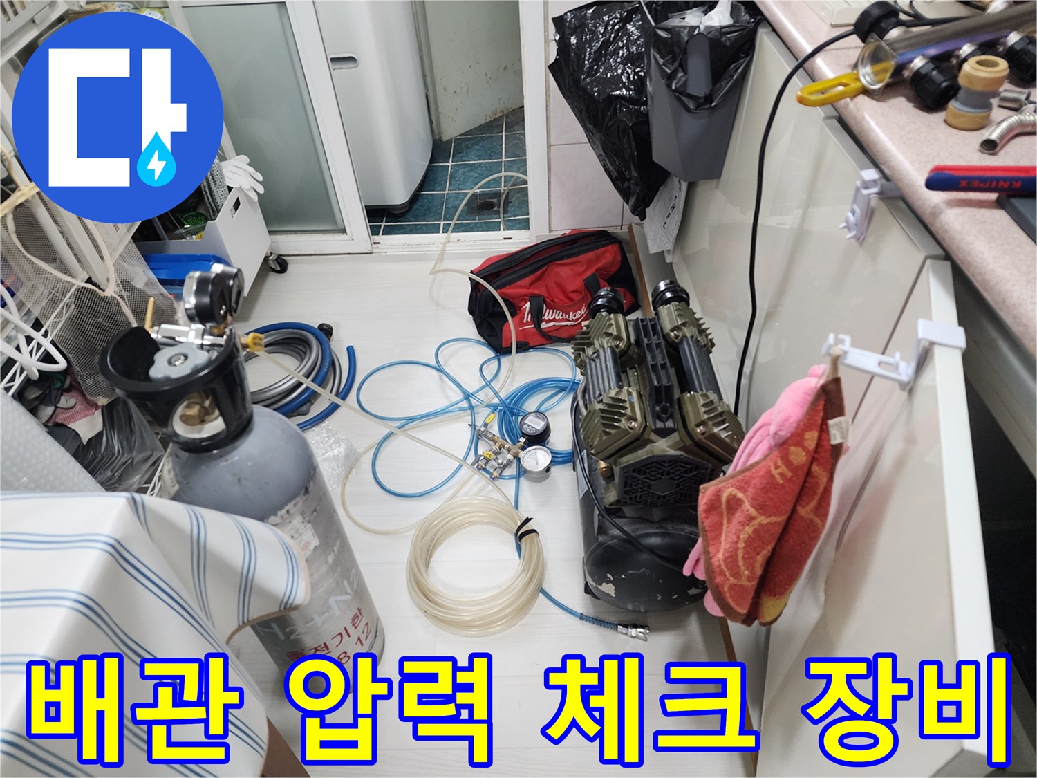 배관 내부의 공기압을 측정하기 위해 설치된 호스와 게이지입니다.