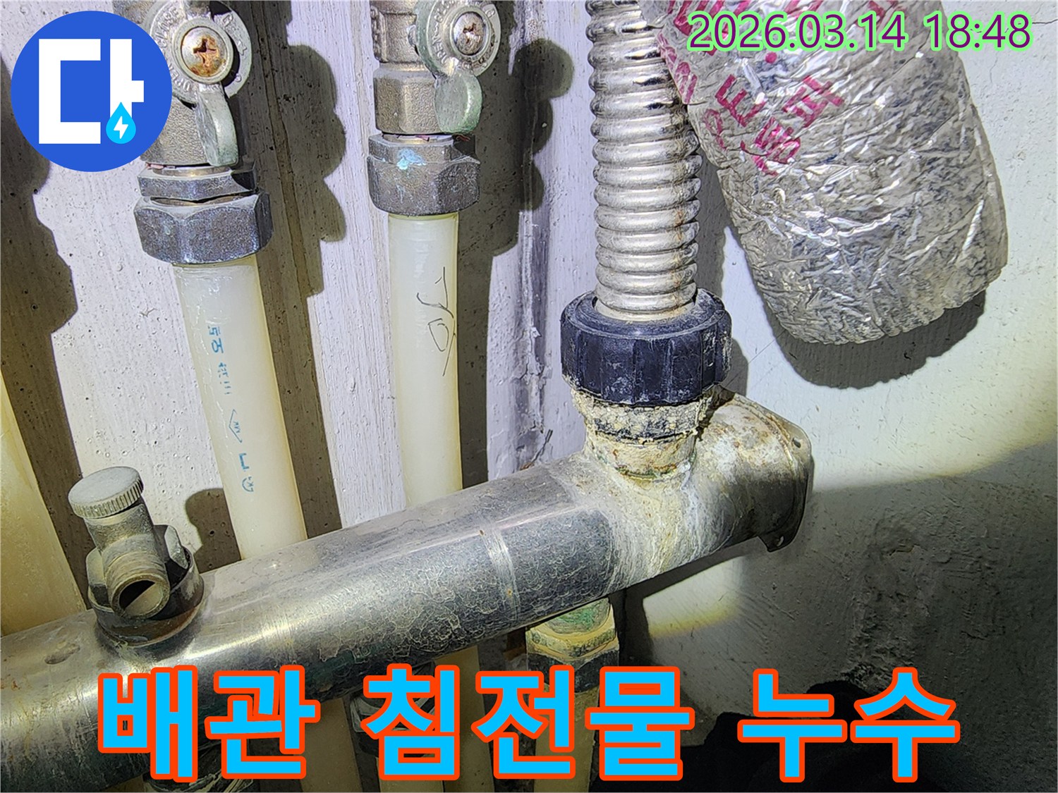 오래된 배관 연결 부위에-하얗게 굳은 석회 침전물이-누수 징후를 명확히 보여주는 모습