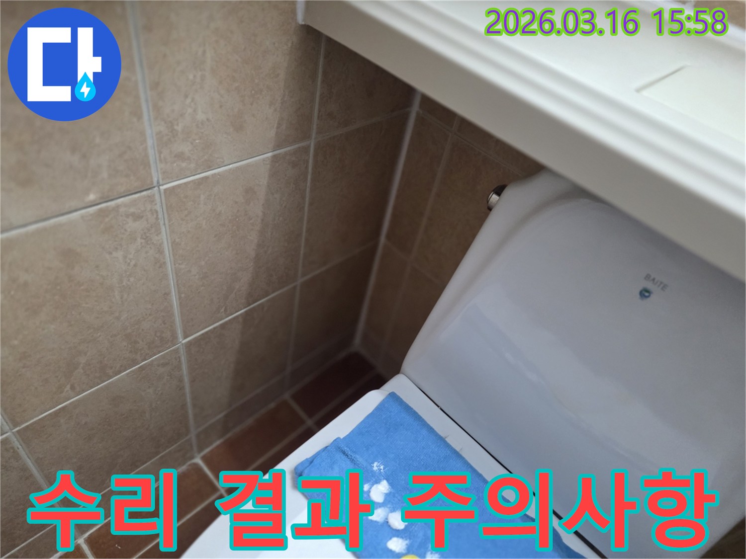 오산시 운암동의-한 욕실에서-변기 뒤편-벽면 타일의 젖음으로-누수 수리 후-고객님께 수리 결과와-주의사항을 설명하는-현장을 보여주는-사진입니다.