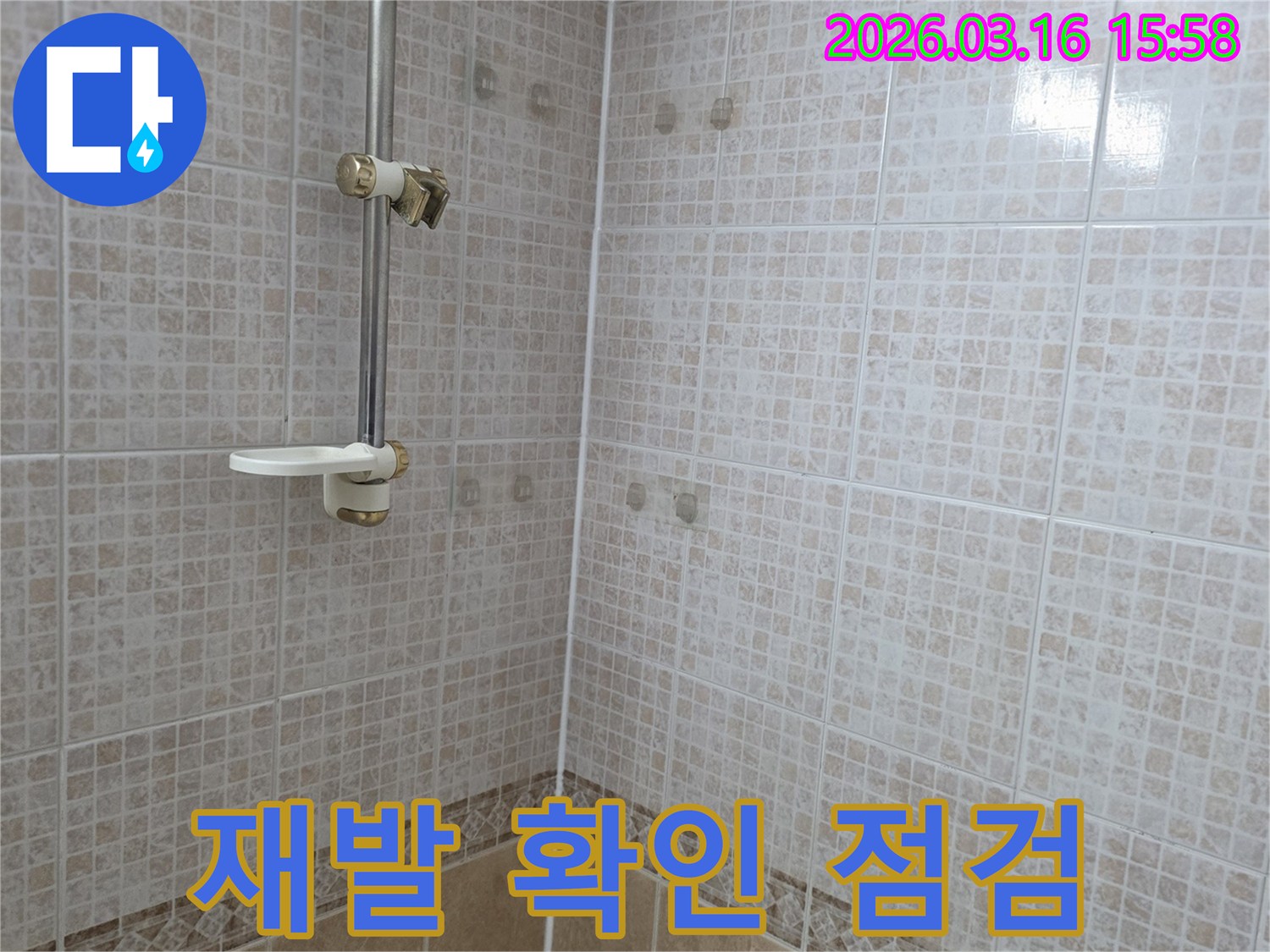 욕실 천장 타일에 물이 새어 생긴-얼룩 공사 후 누수 재발 여부를-철저히 확인 점검하는 누수 전문가의 모습
