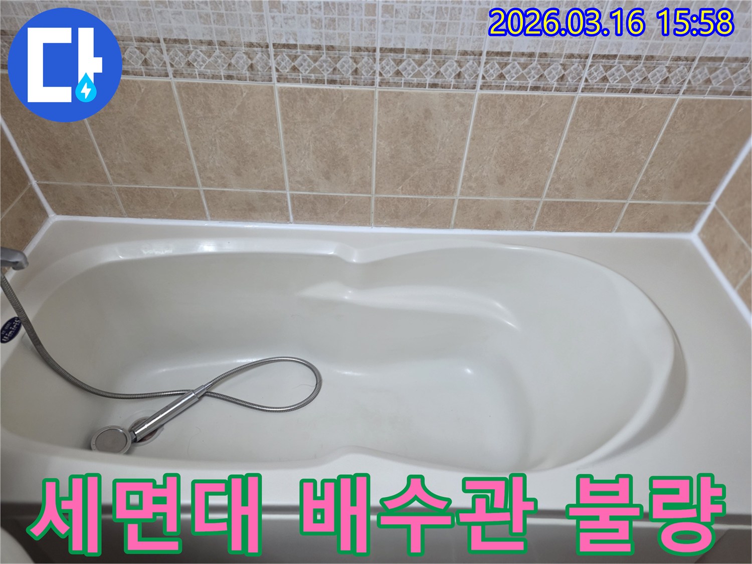 욕실의-흰색-욕조와-타일-그리고-샤워기가-보이는-세면대-배수관-연결-불량으로-인한-누수를-점검하는-현장-사진입니다