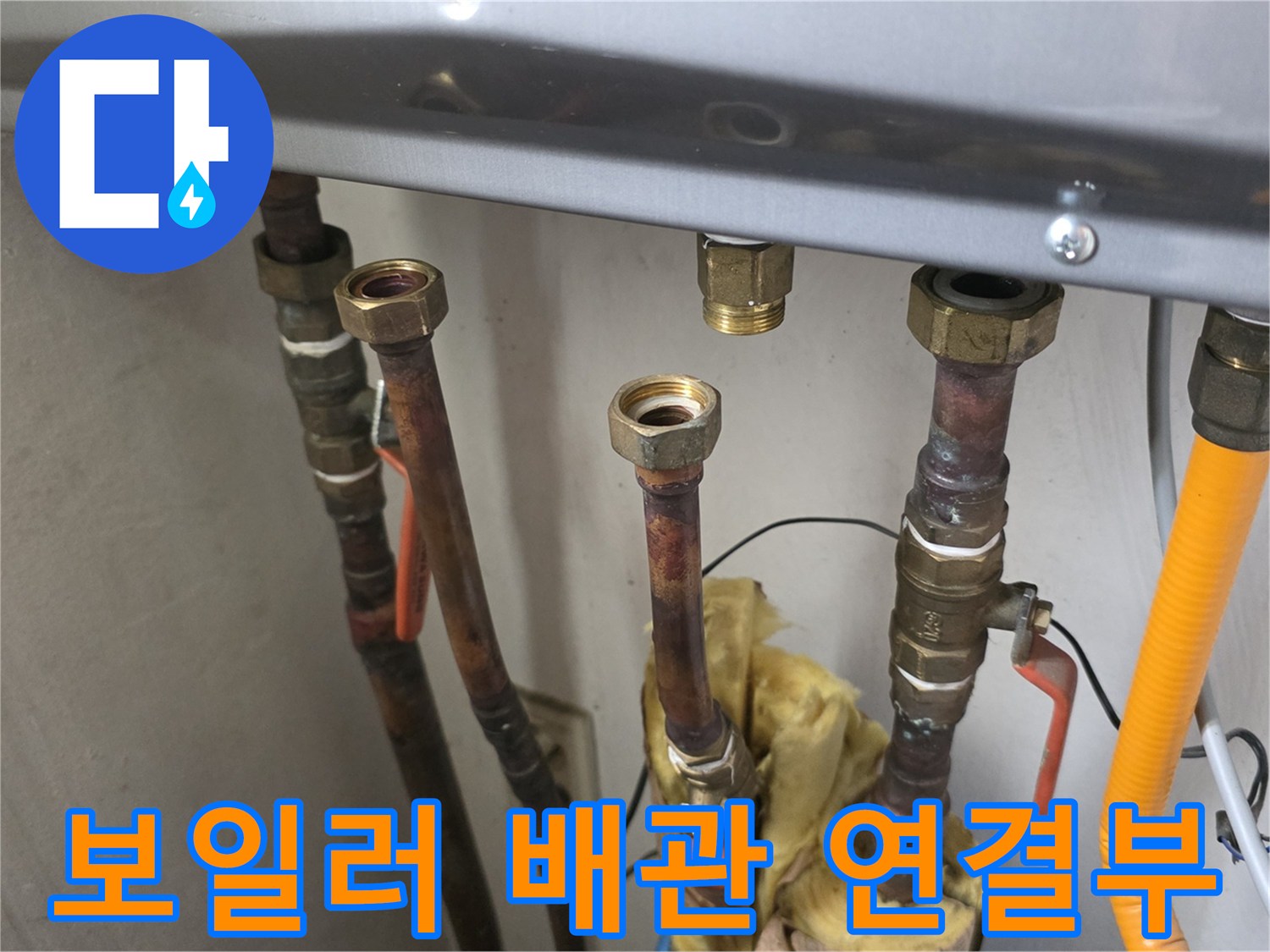금속 재질의 보일러 배관과 조절 밸브가 설치된 모습입니다.