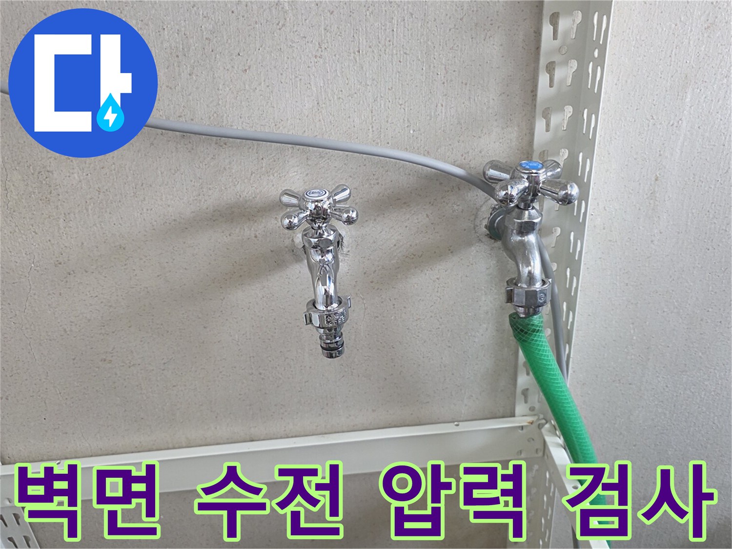 수도꼭지에 연결된 초록색 호스와 벽면 배관 모습