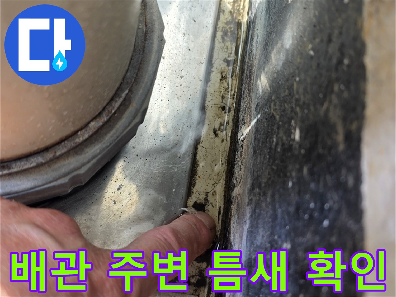 화장실 배관 관통 부위의 틈새를 손으로 점검하는 모습