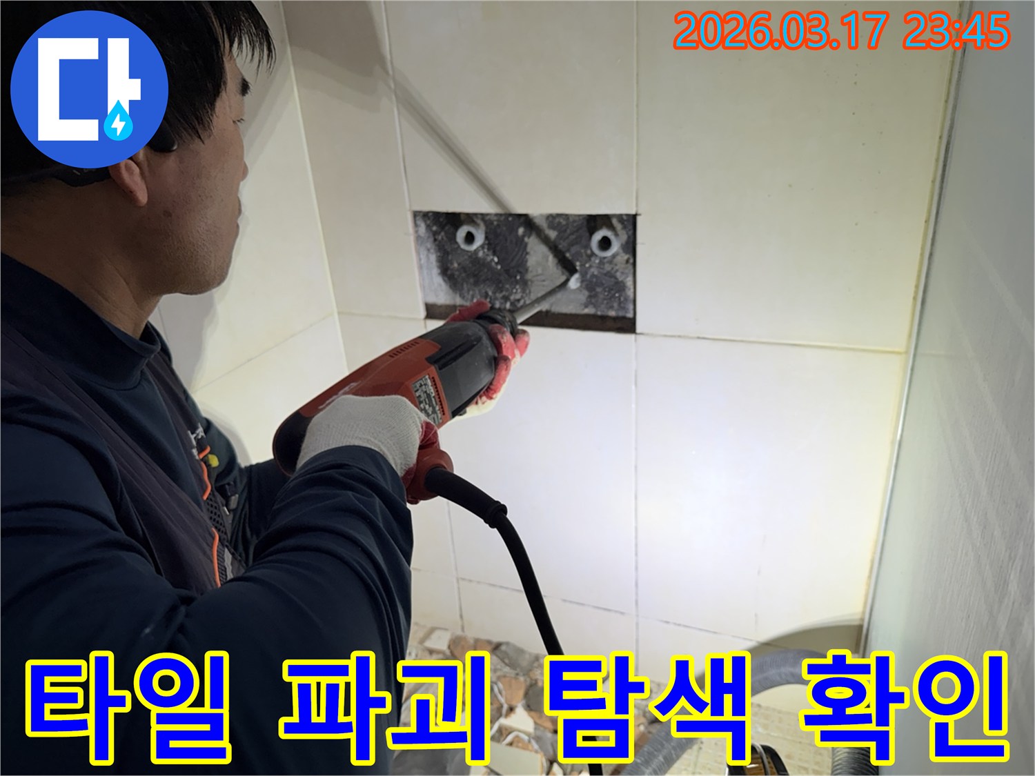 누수 전문가가 아파트 벽면 타일을 파괴하여-숨겨진 배관의 누수 지점을 정밀하게 탐색하고 확인하는 작업 현장입니다.