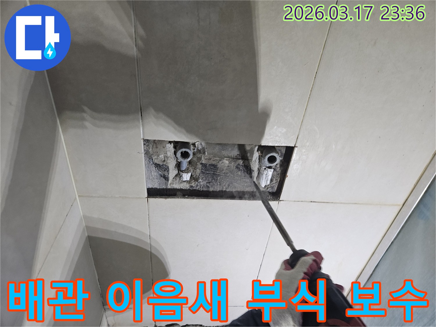 누수 지점을-찾기 위해-타일이 제거된-벽면에서-배관 이음새의-부식 여부를-점검하는-모습입니다